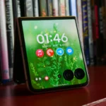 Điện thoại gập Motorola Razr Ultra (2025) với màn hình phụ hiển thị thông tin, đặt trên kệ sách.