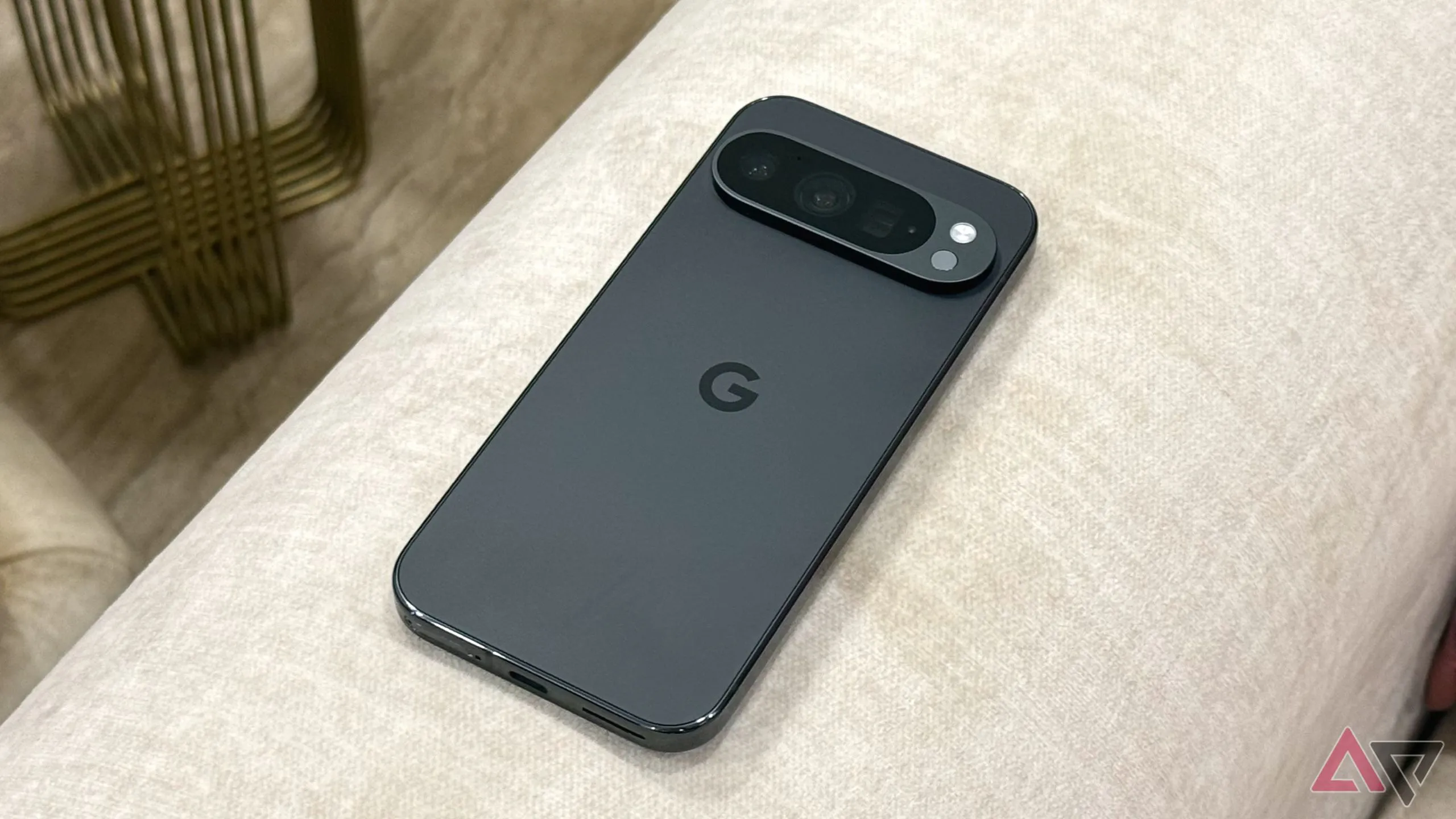Điện thoại Pixel 9 Pro màu xanh đặt trên ghế sofa