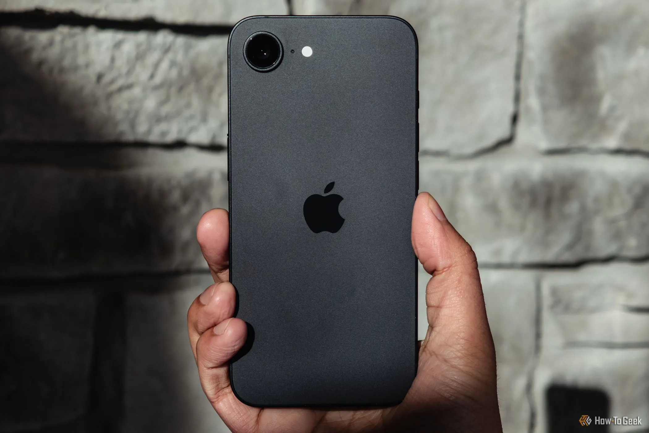 Hình ảnh một chiếc iPhone đang được cầm trên tay, minh họa thiết bị chạy hệ điều hành iOS 26.
