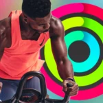 Huấn luyện viên Apple Fitness+ trước hình ảnh vòng Hoạt động (Activity Rings) của Apple Watch.