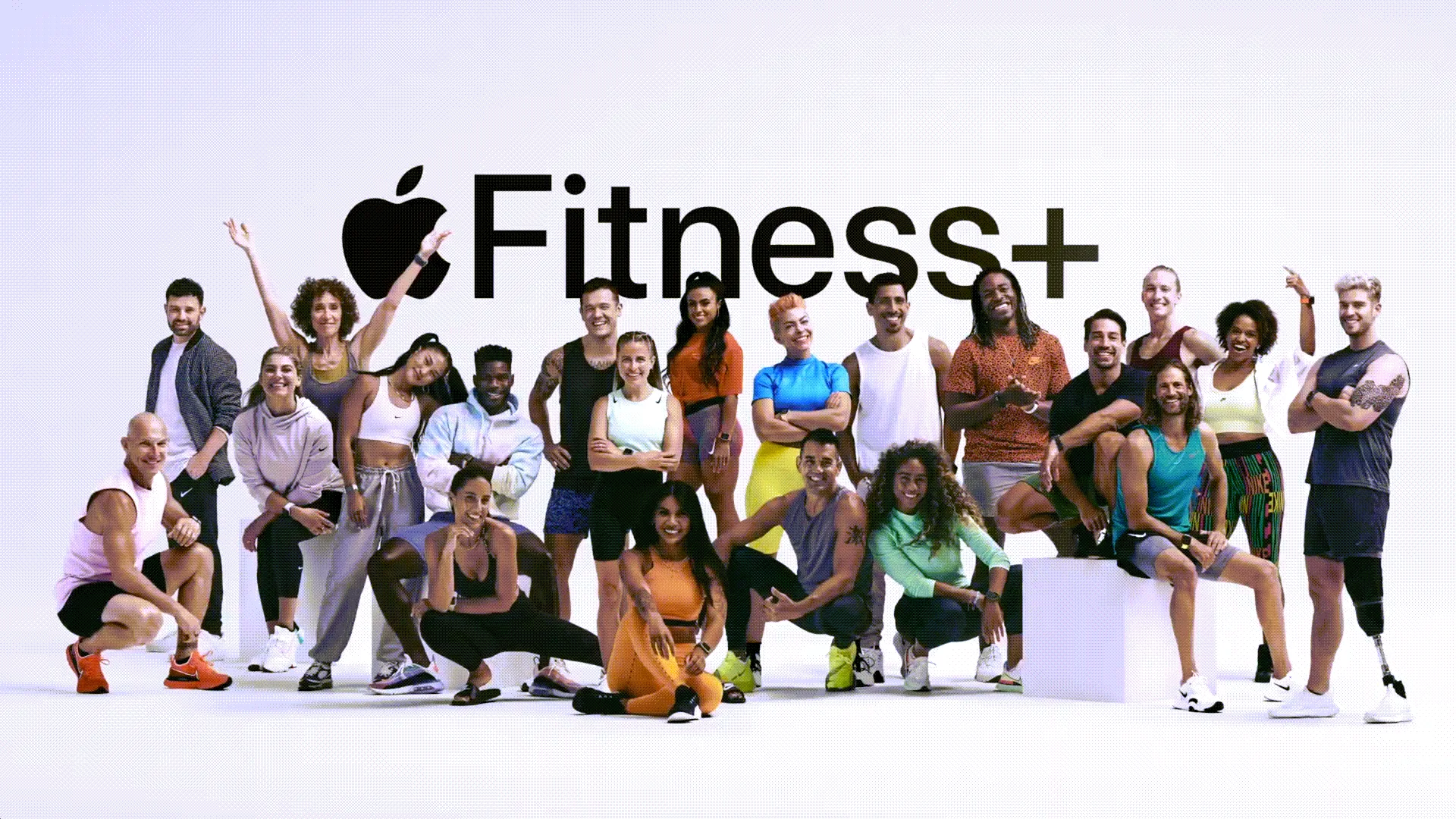 Một nhóm lớn các huấn luyện viên cá nhân trước logo Fitness+.