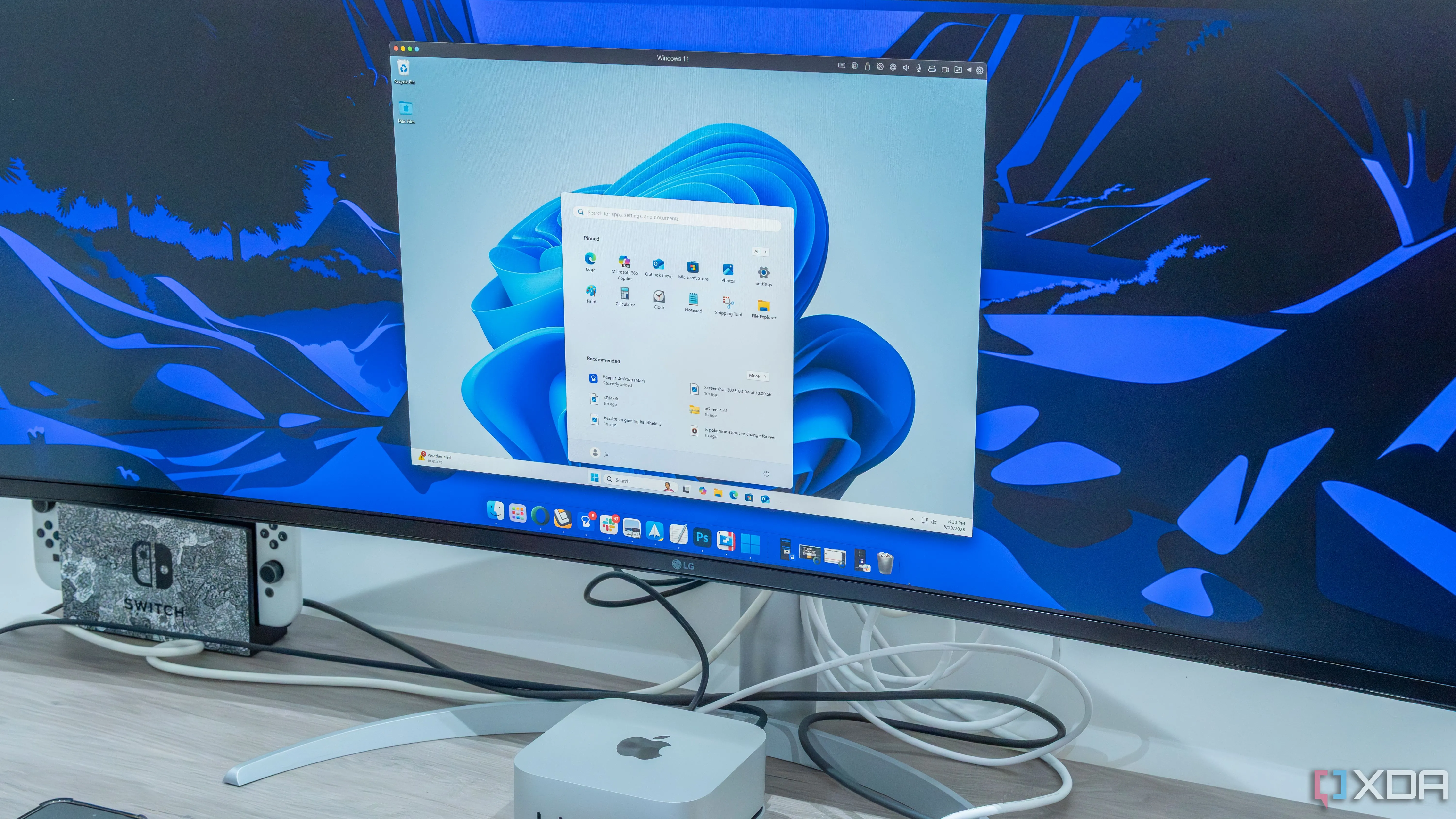 Máy Mac Mini đặt dưới màn hình cho thấy phần mềm Parallels ảo hóa Windows