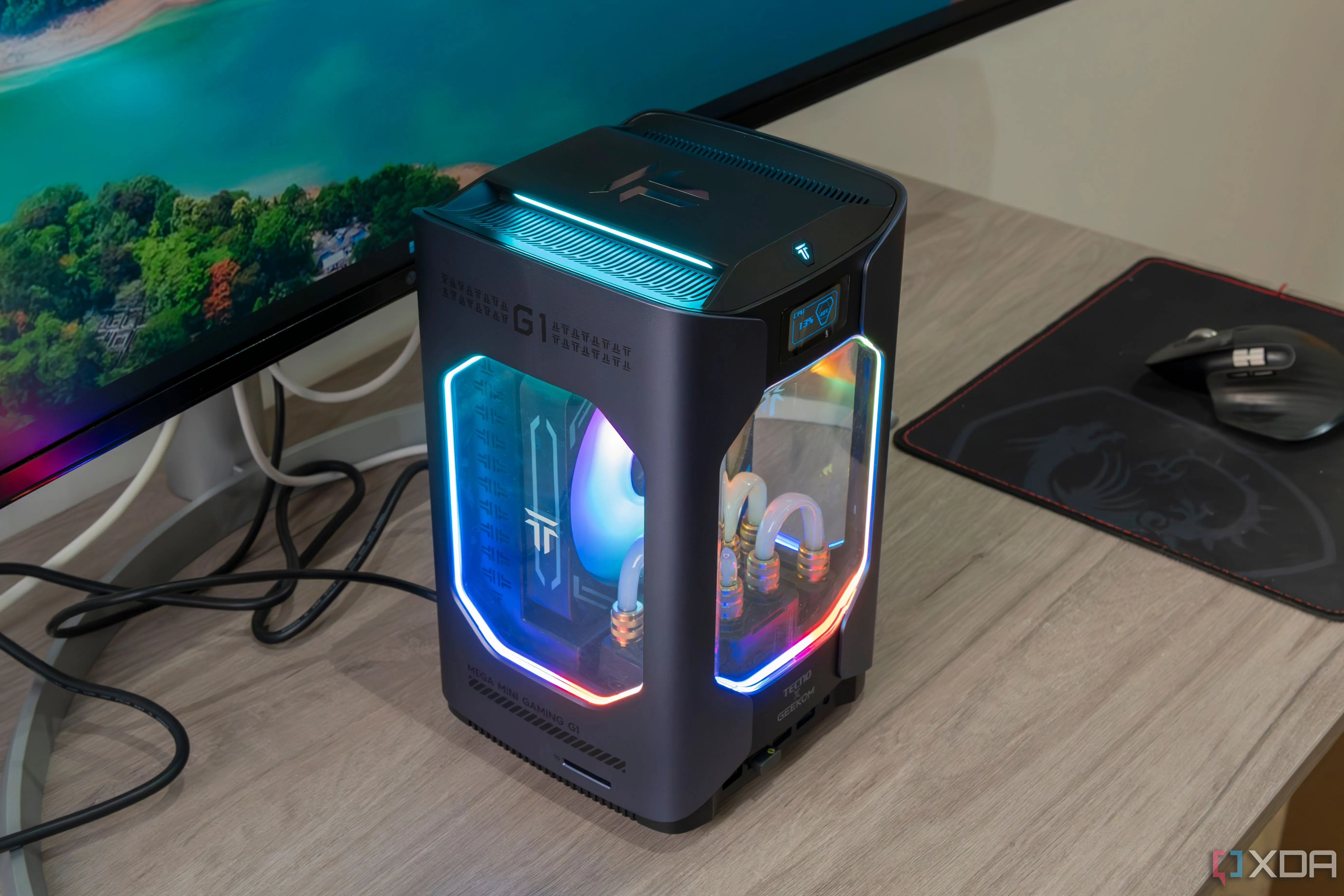 Máy tính mini Geekom Megamini G1 màu bạc đặt trên bàn gỗ, biểu tượng cho thiết kế nhỏ gọn và khả năng hoạt động êm ái.