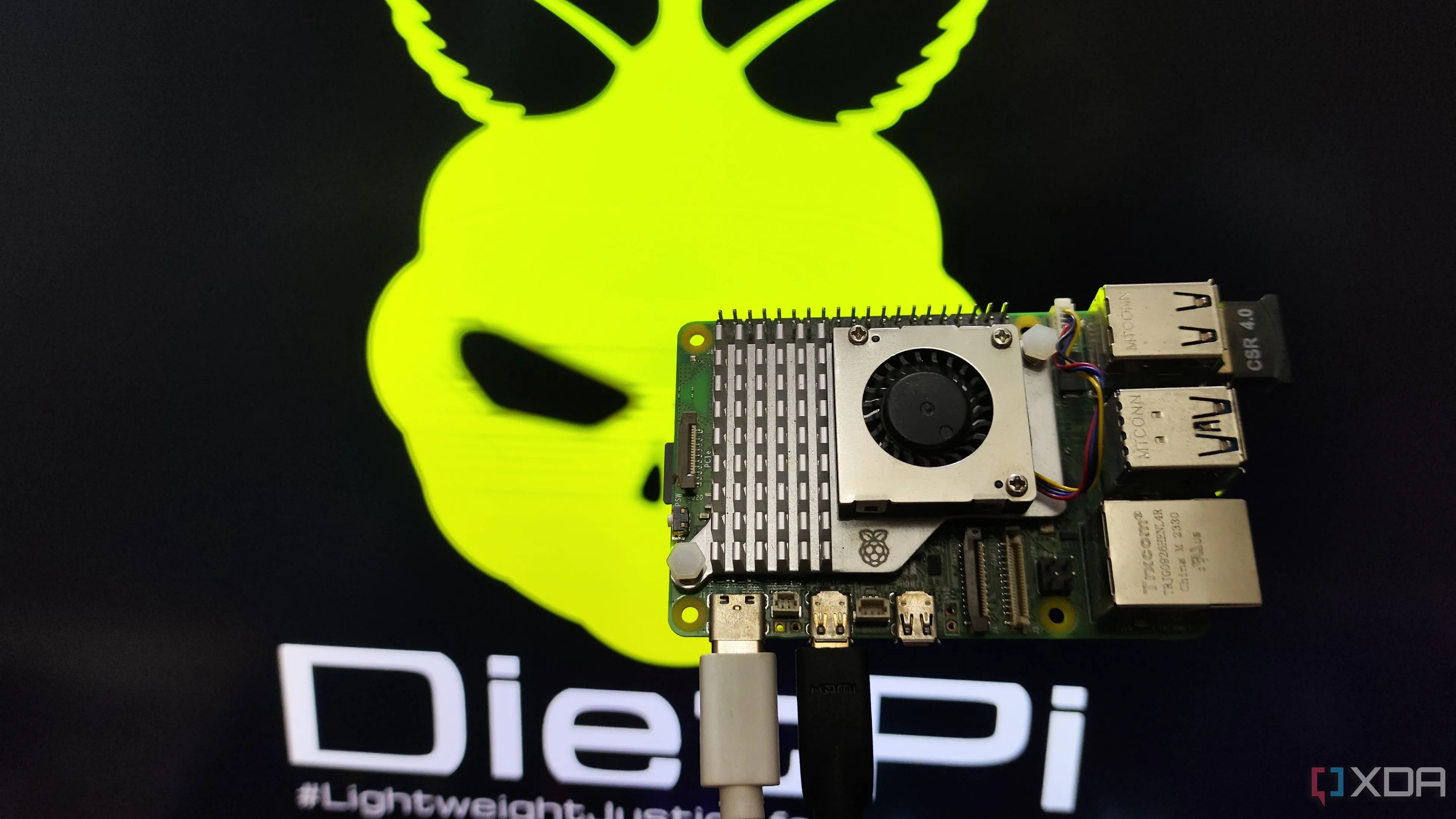 Một người dùng đang cầm Raspberry Pi 5 trước màn hình hiển thị môi trường máy tính để bàn DietPi LXDE, minh họa khả năng hoạt động của DietPi trên các máy tính nhúng.
