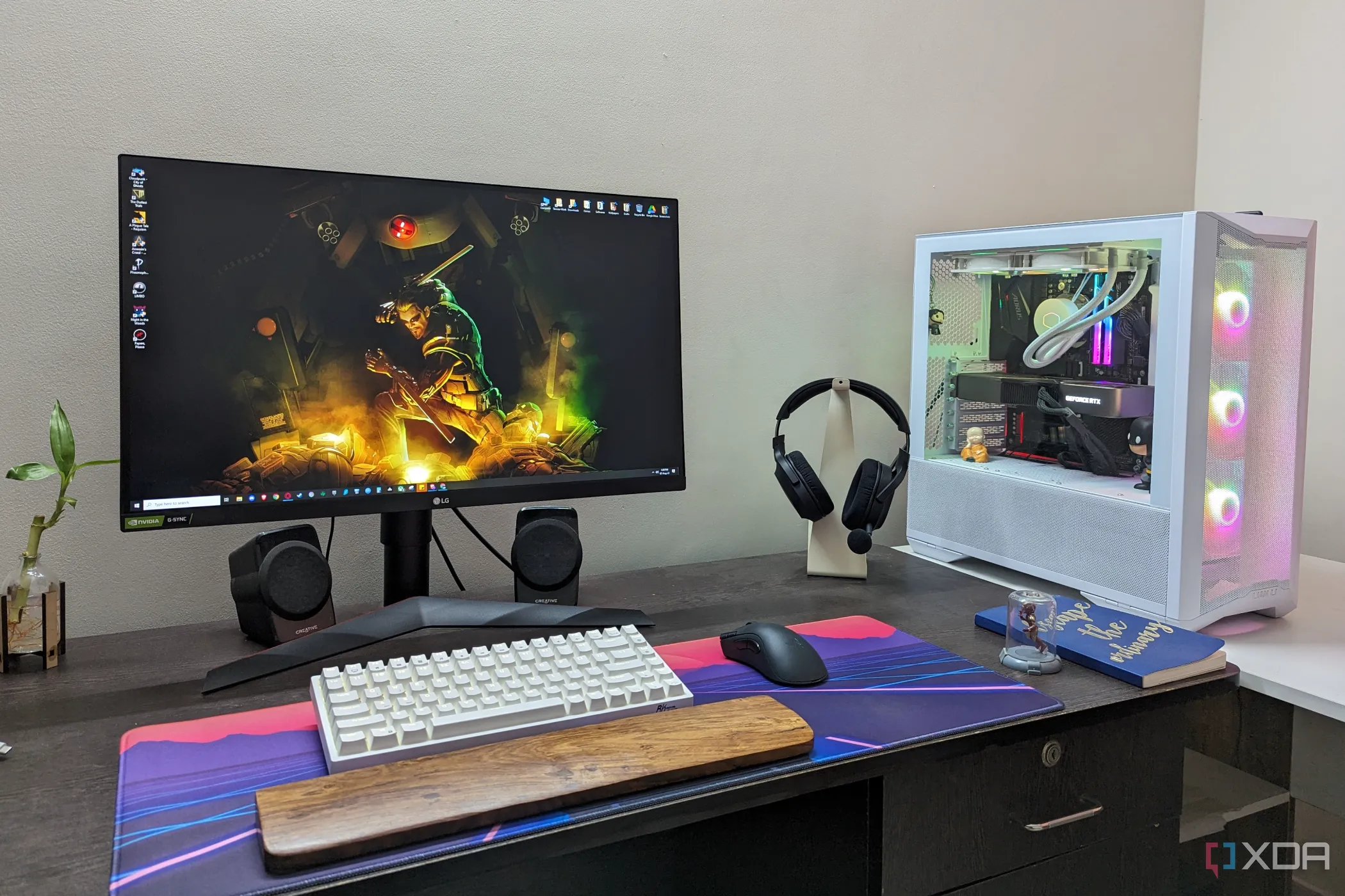 Thiết lập máy tính để bàn với PC chơi game, màn hình, bàn phím, chuột và tai nghe, nhấn mạnh tầm quan trọng của hiệu suất ổn định khi chơi game trên Windows 11.