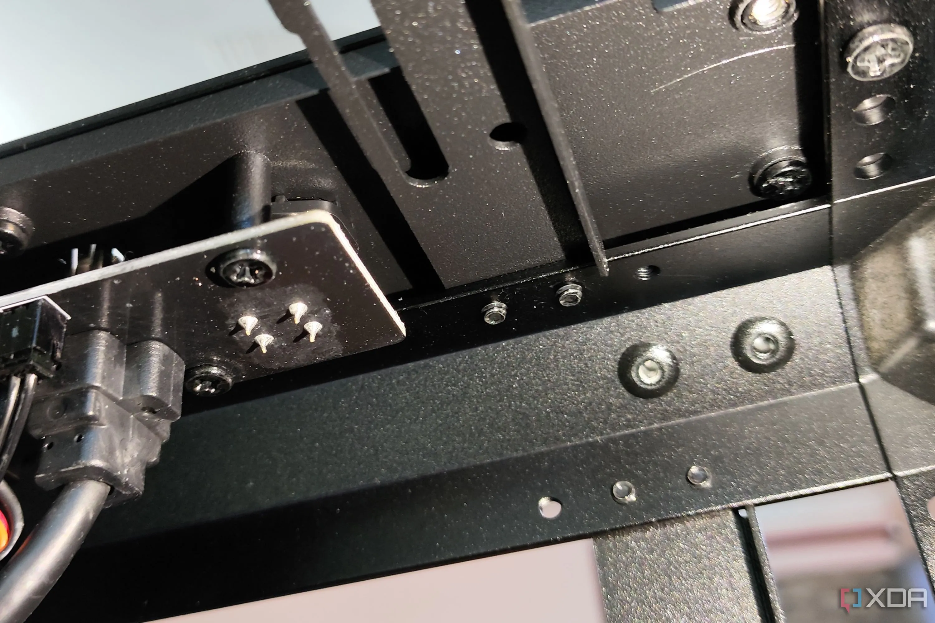 Vị trí ốc vít khó tiếp cận dưới khu vực I/O mặt trước của vỏ case Cooler Master MasterFrame 600, hạn chế khả năng tùy chỉnh