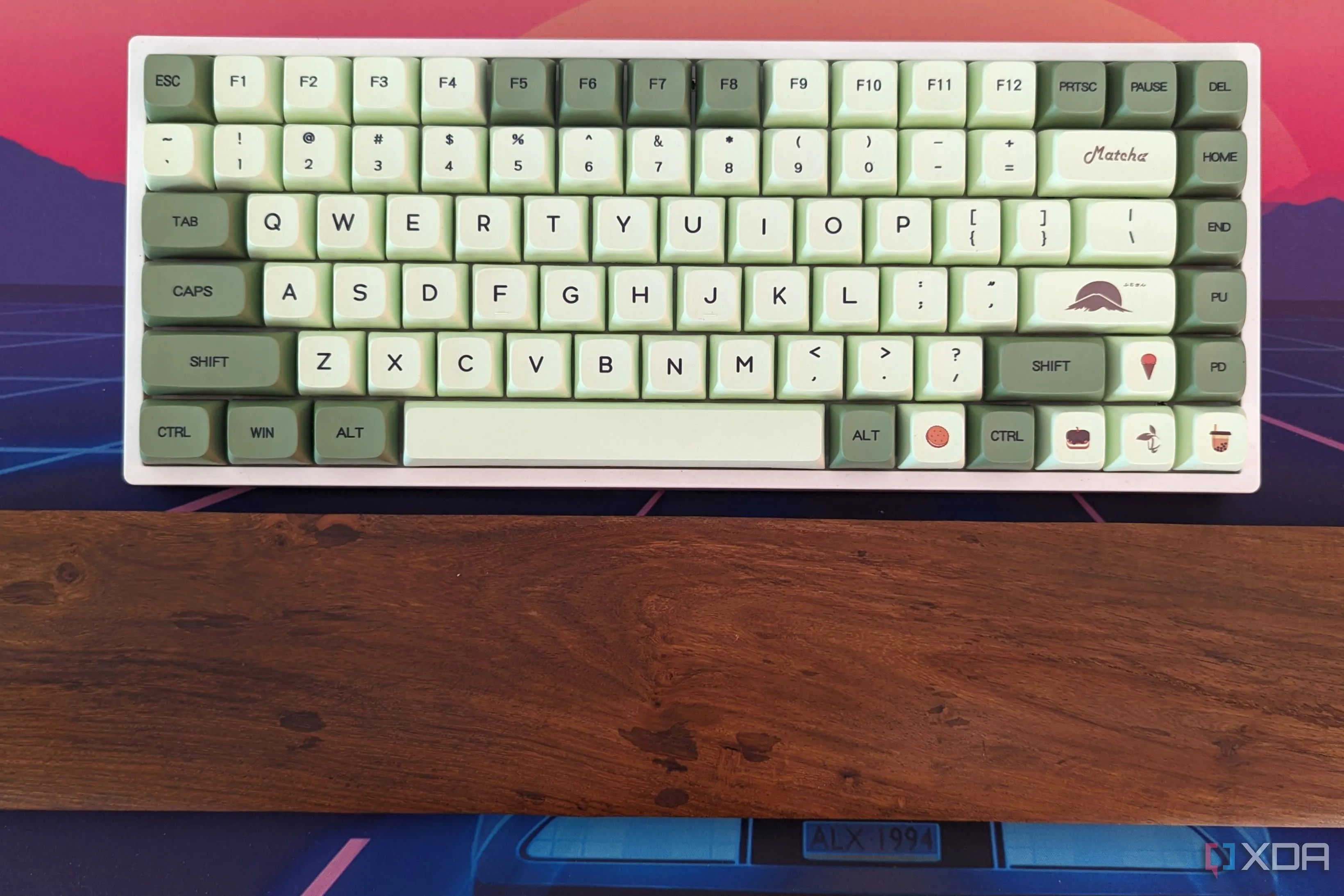 Bàn phím cơ RK84 với keycap tùy chỉnh và kê tay gỗ đơn giản.