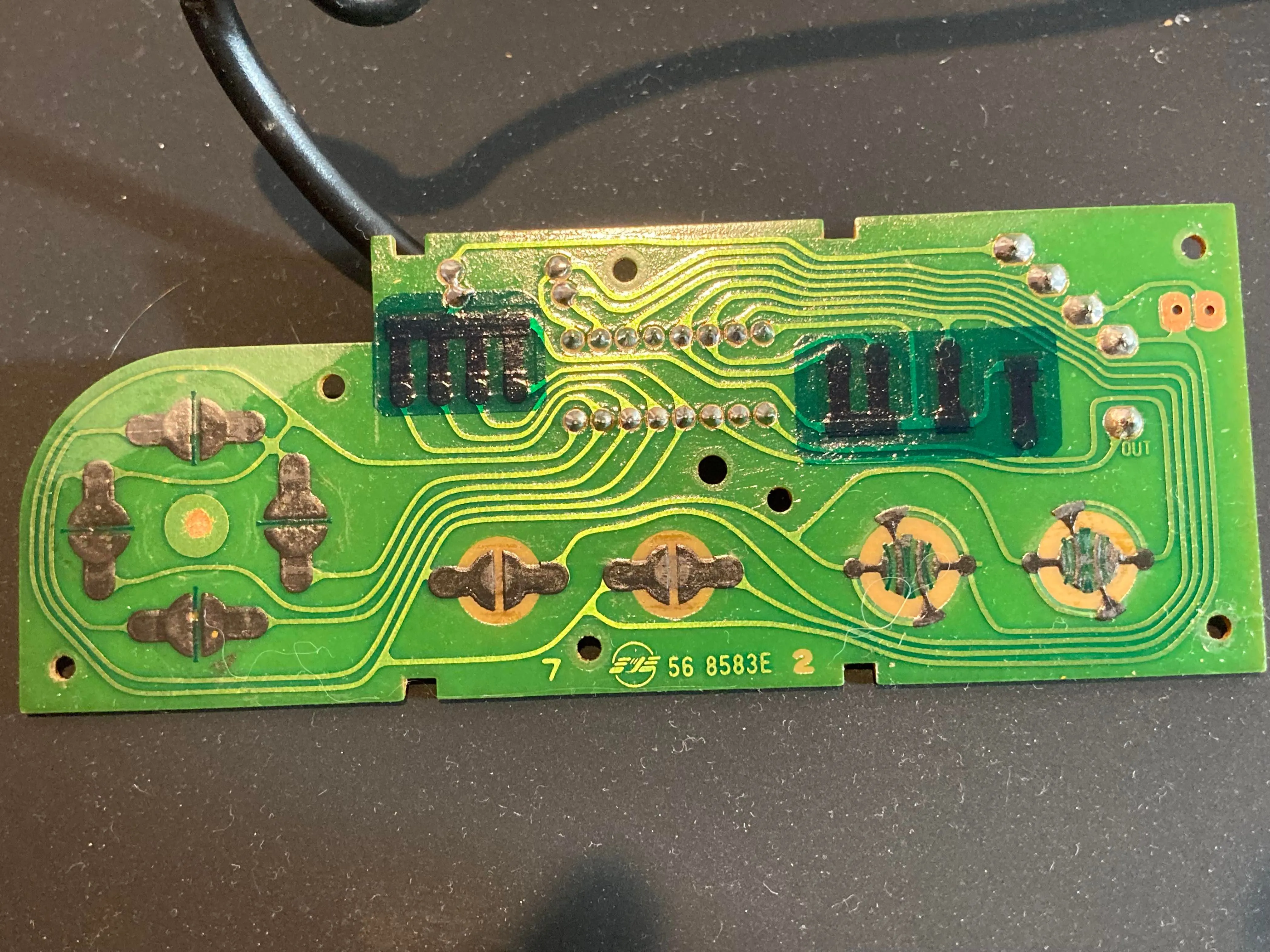 Bảng mạch in (PCB) bên trong mặt trước của tay cầm NES, hiển thị các tiếp điểm nút bấm và chip BU4021B