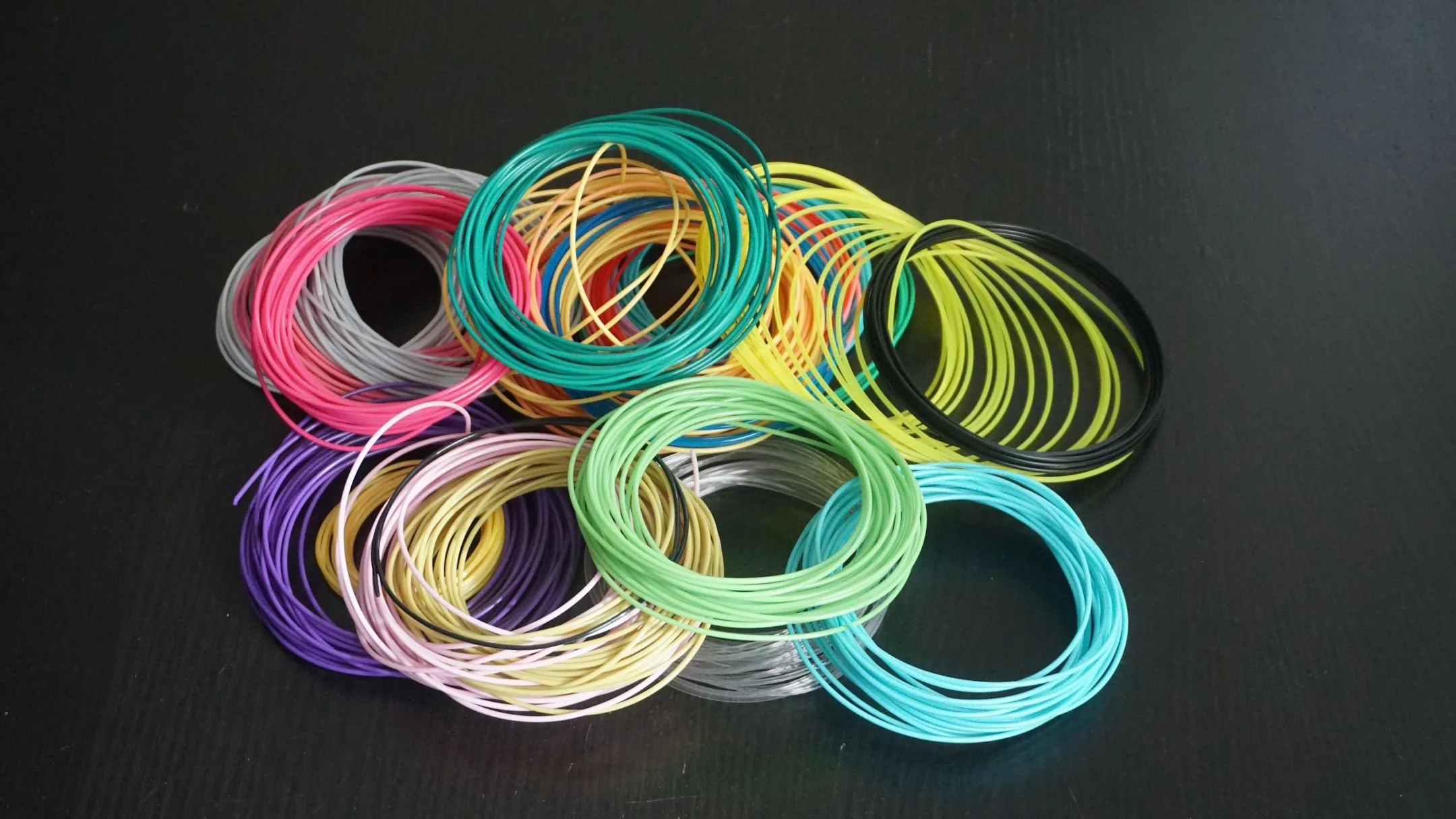 Cuộn dây nhựa in 3D (filament) màu vàng cam, tượng trưng cho vật liệu in 3D