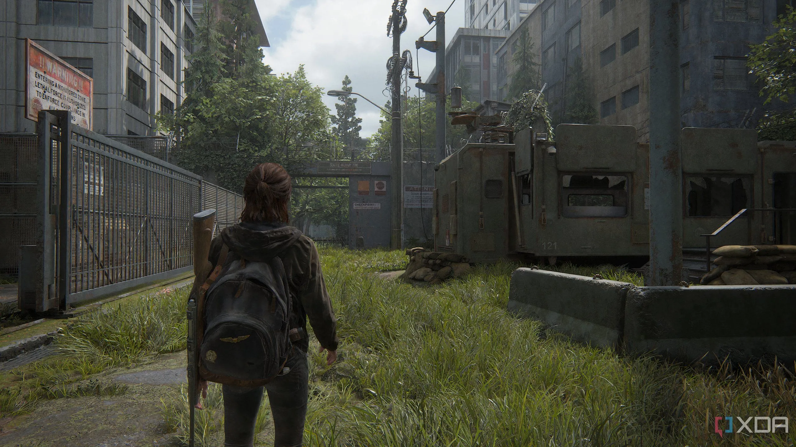 Ellie khám phá khu phức hợp quân sự trong một cảnh đồ họa ấn tượng của The Last of Us Part II Remastered trên PC.