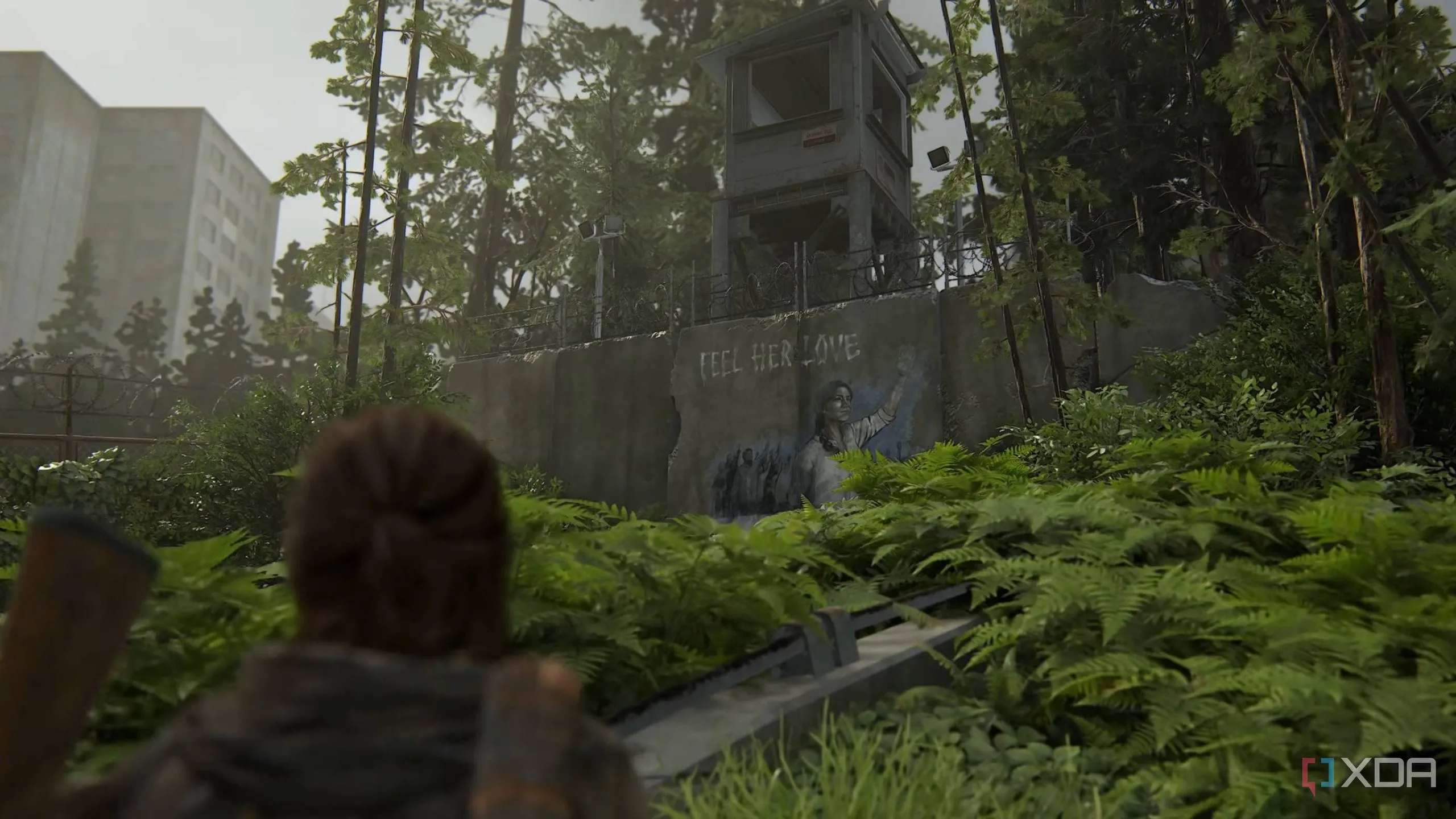 Ellie quan sát bức tranh tường của Seraphites (Scars) trong game The Last of Us Part II Remastered.