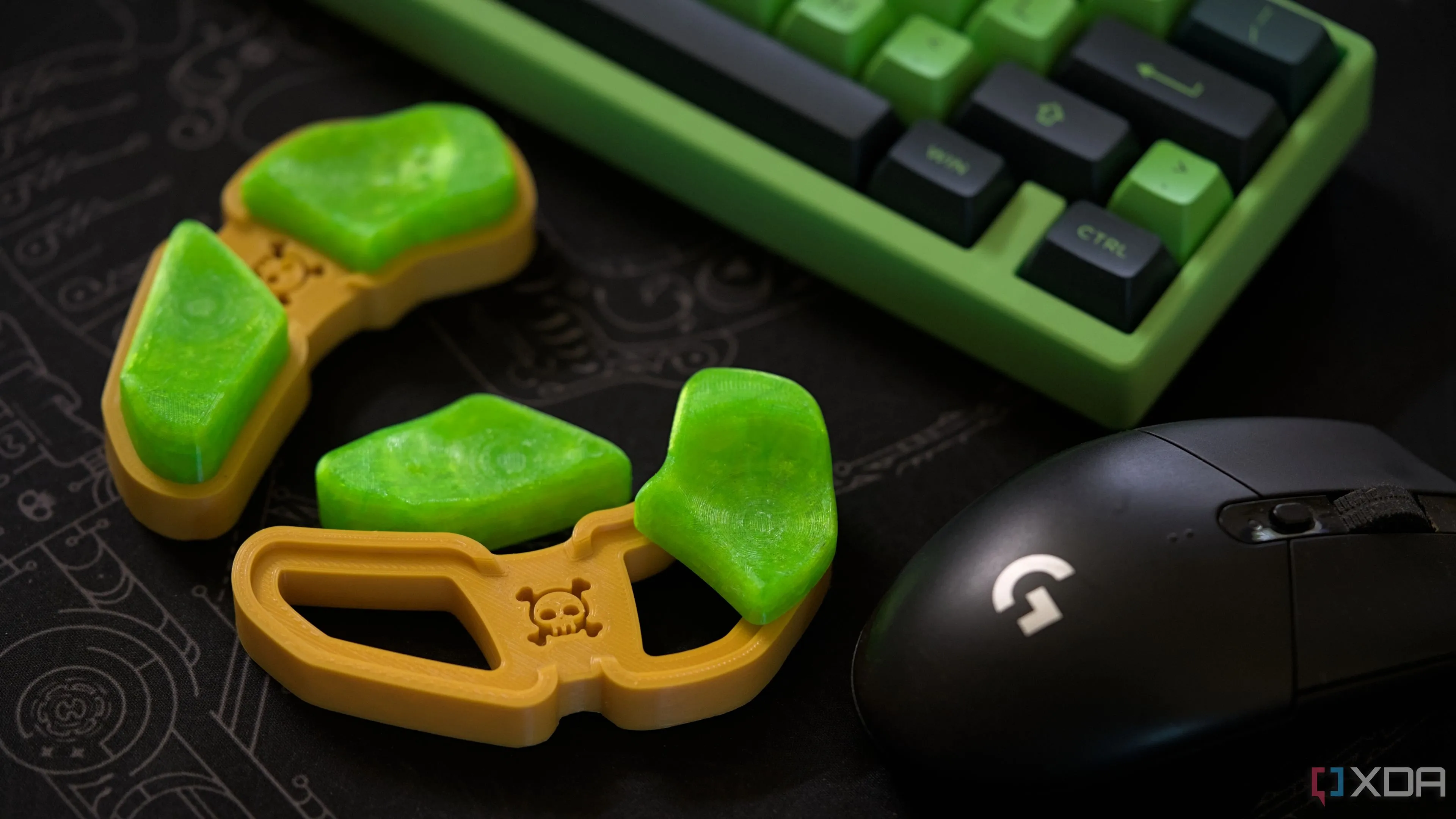 Giá đỡ cổ tay màu vàng với đệm xanh neon trên bàn làm việc đen cùng bàn phím và chuột chơi game màu xanh lá cây.