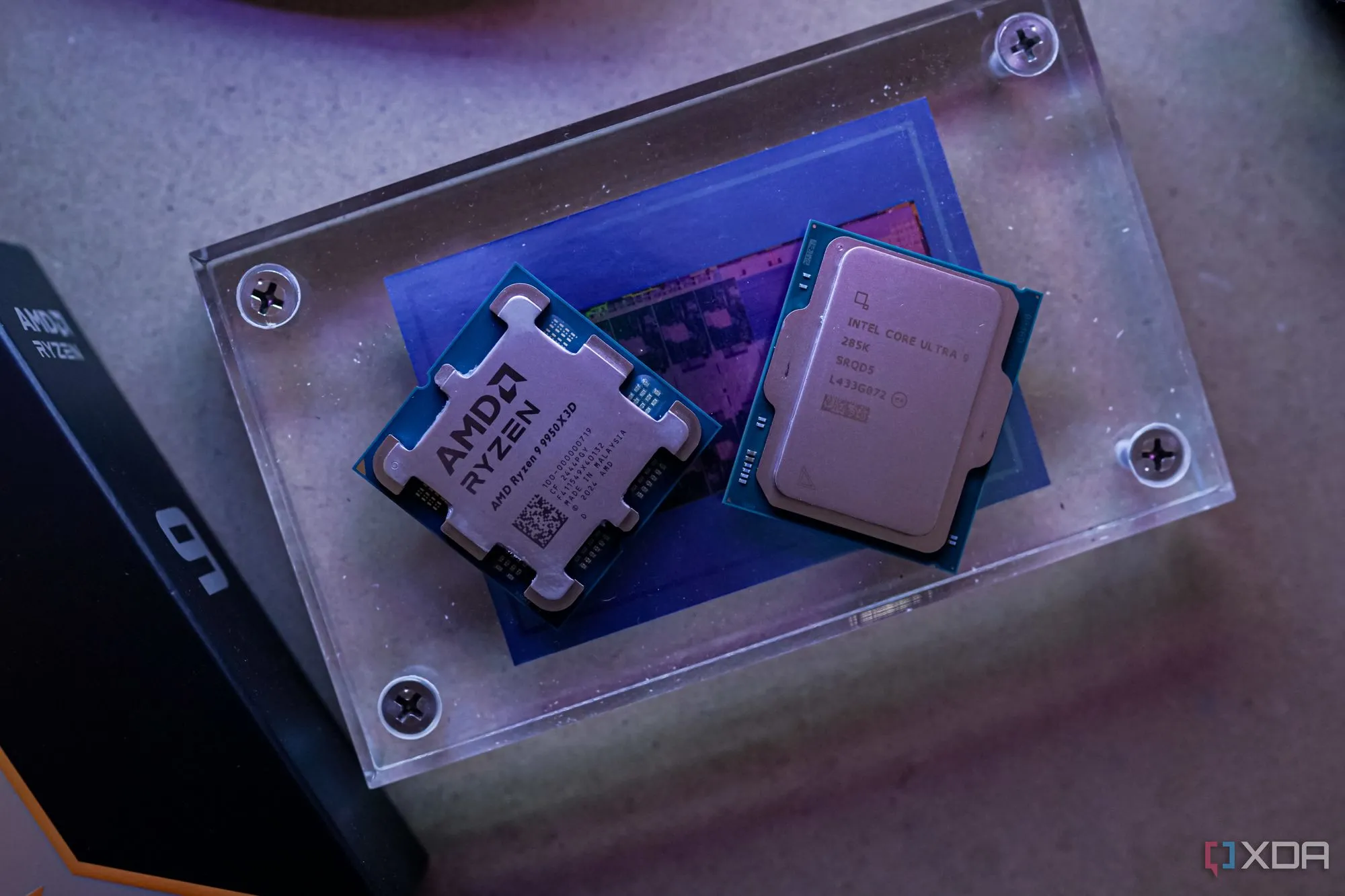 Hai bộ vi xử lý AMD Ryzen 9 9950X3D và Intel Core Ultra 9 285K đặt cạnh nhau trên bàn.