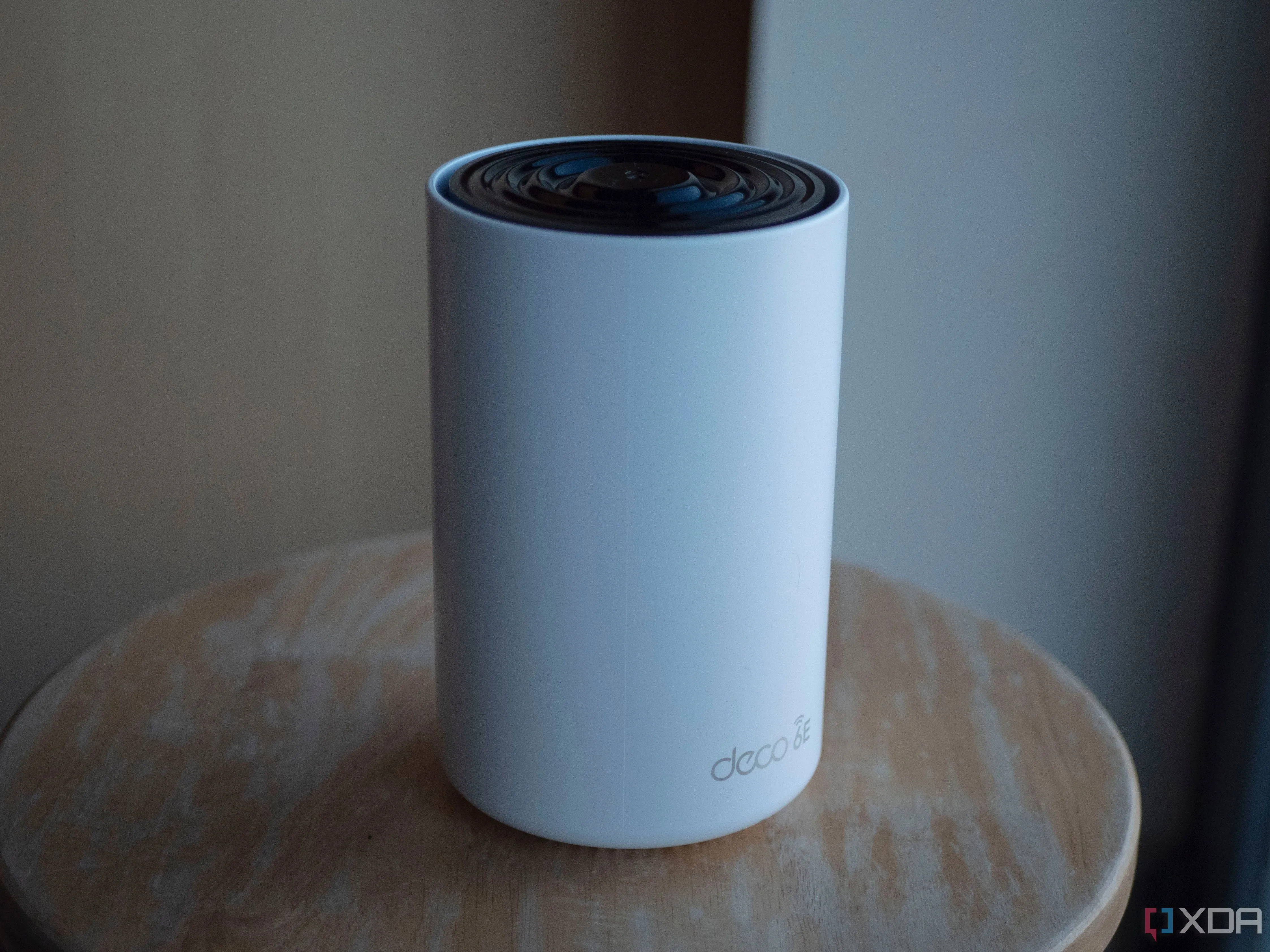 Hệ thống WiFi Mesh TP-Link Deco XE75 đặt trên bàn với ánh nắng mặt trời chiếu vào, tượng trưng cho kết nối không dây hiện đại