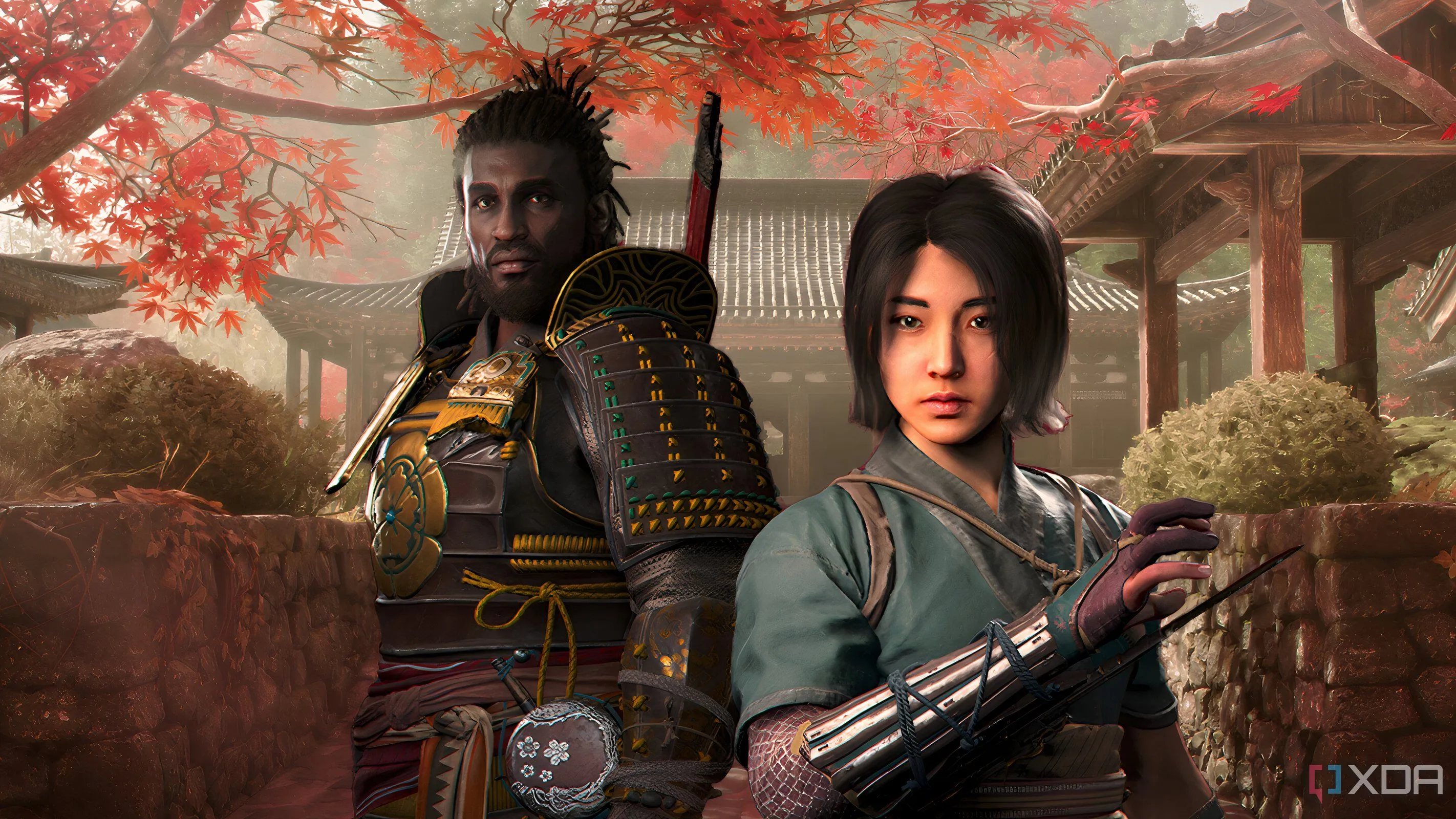 Hình ảnh Naoe và Yasuke đứng trước kiến trúc Nhật Bản và cây lá đỏ trong Assassin's Creed Shadows