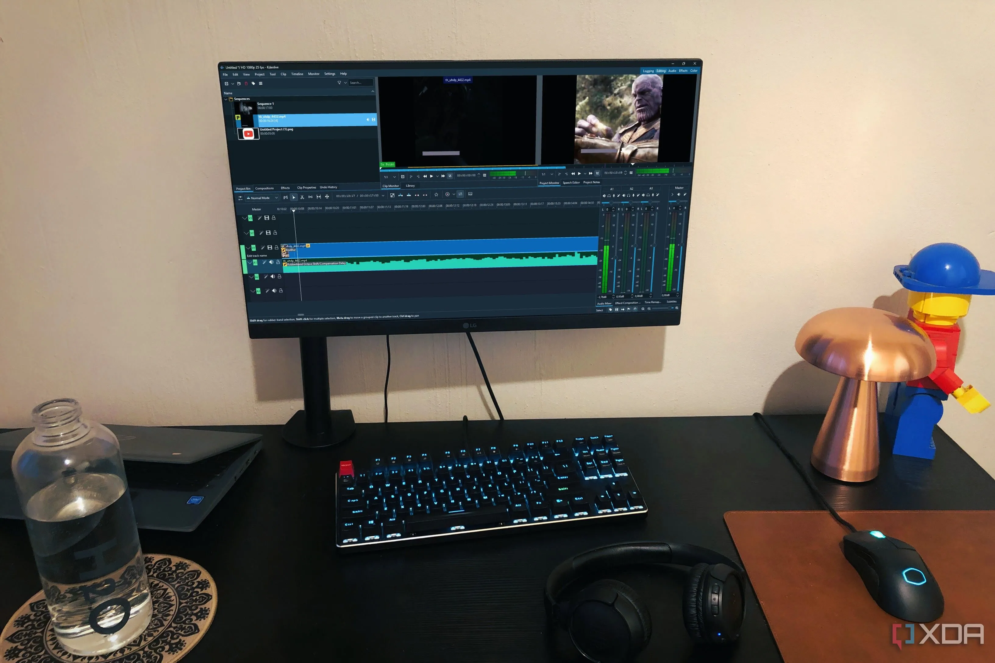 Kdenlive trên màn hình máy tính để bàn, cho thấy giao diện chỉnh sửa video với các vật dụng cá nhân xung quanh, minh họa khả năng ứng dụng thực tế.