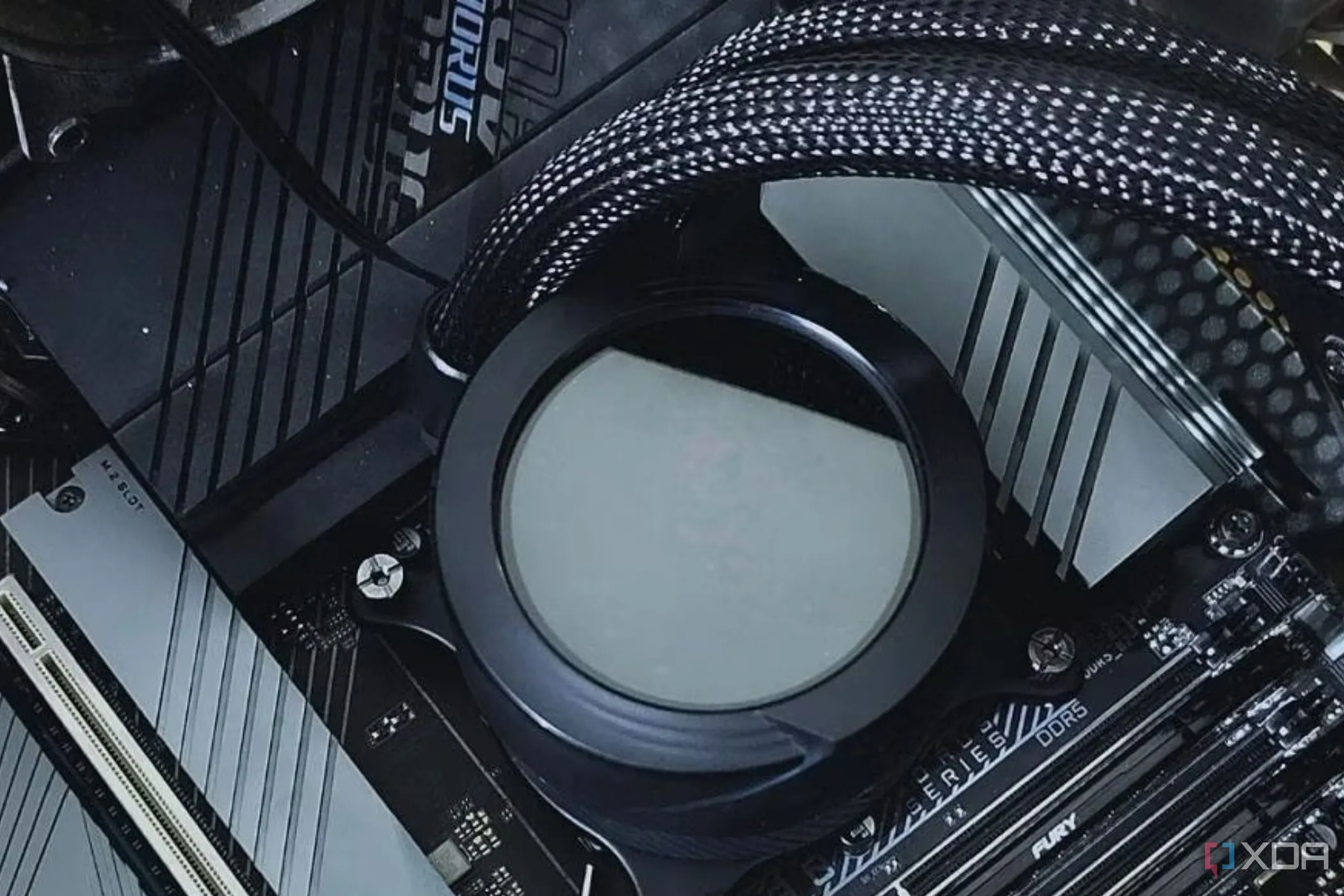 Khối tản nhiệt (waterblock) của tản nhiệt nước AIO được lắp trên bo mạch chủ, minh họa quá trình cài đặt phức tạp của hệ thống làm mát chất lỏng.
