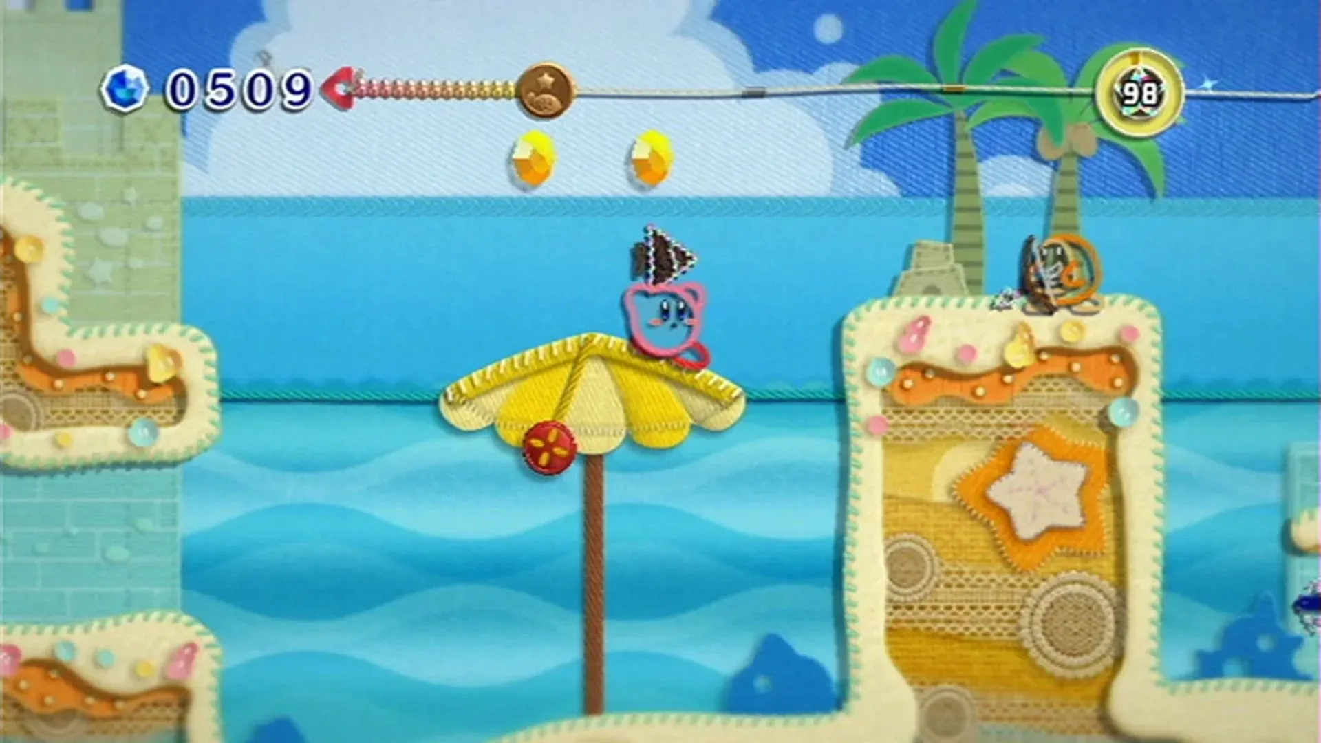 Kirby trên bãi biển trong game Kirby's Epic Yarn, đồ họa len sợi độc đáo