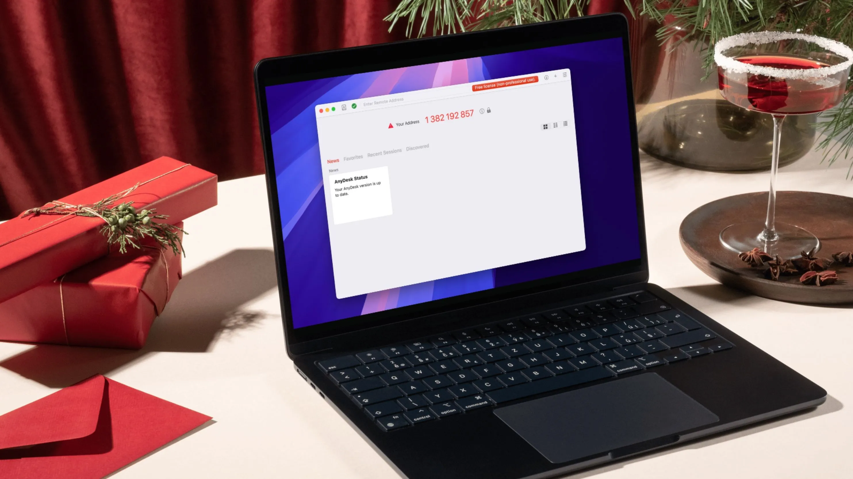 Laptop mở nắp đặt trên bàn làm việc cạnh ly rượu, minh họa làm việc từ xa