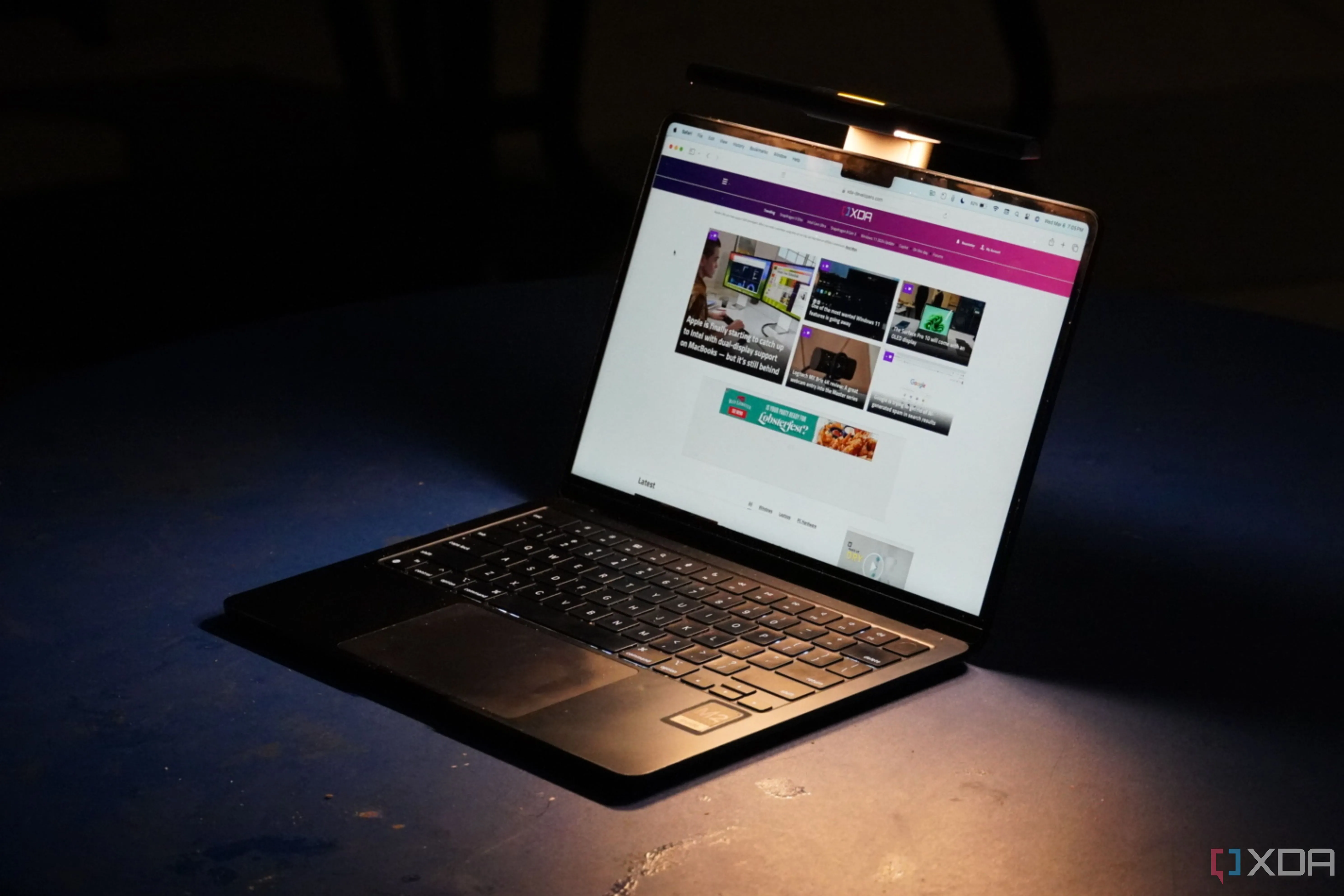 MacBook Air M2 với thanh đèn BenQ LaptopBar đang hoạt động trong môi trường tối, minh họa thiết bị MacBook hiện đại.