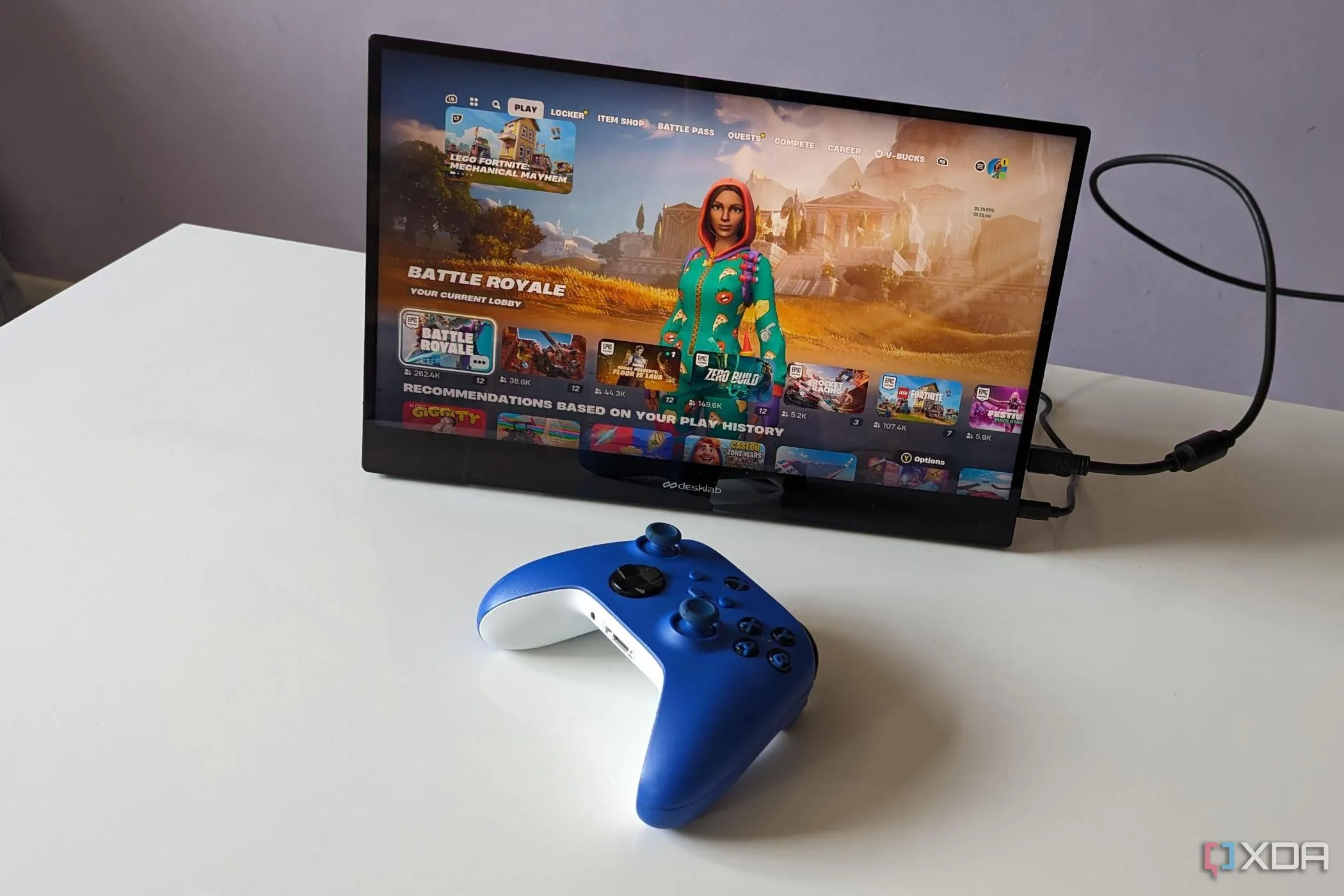 Màn hình Desklabs Portable Monitor hiển thị game Fortnite cùng tay cầm Xbox, minh họa việc chơi game Fortnite