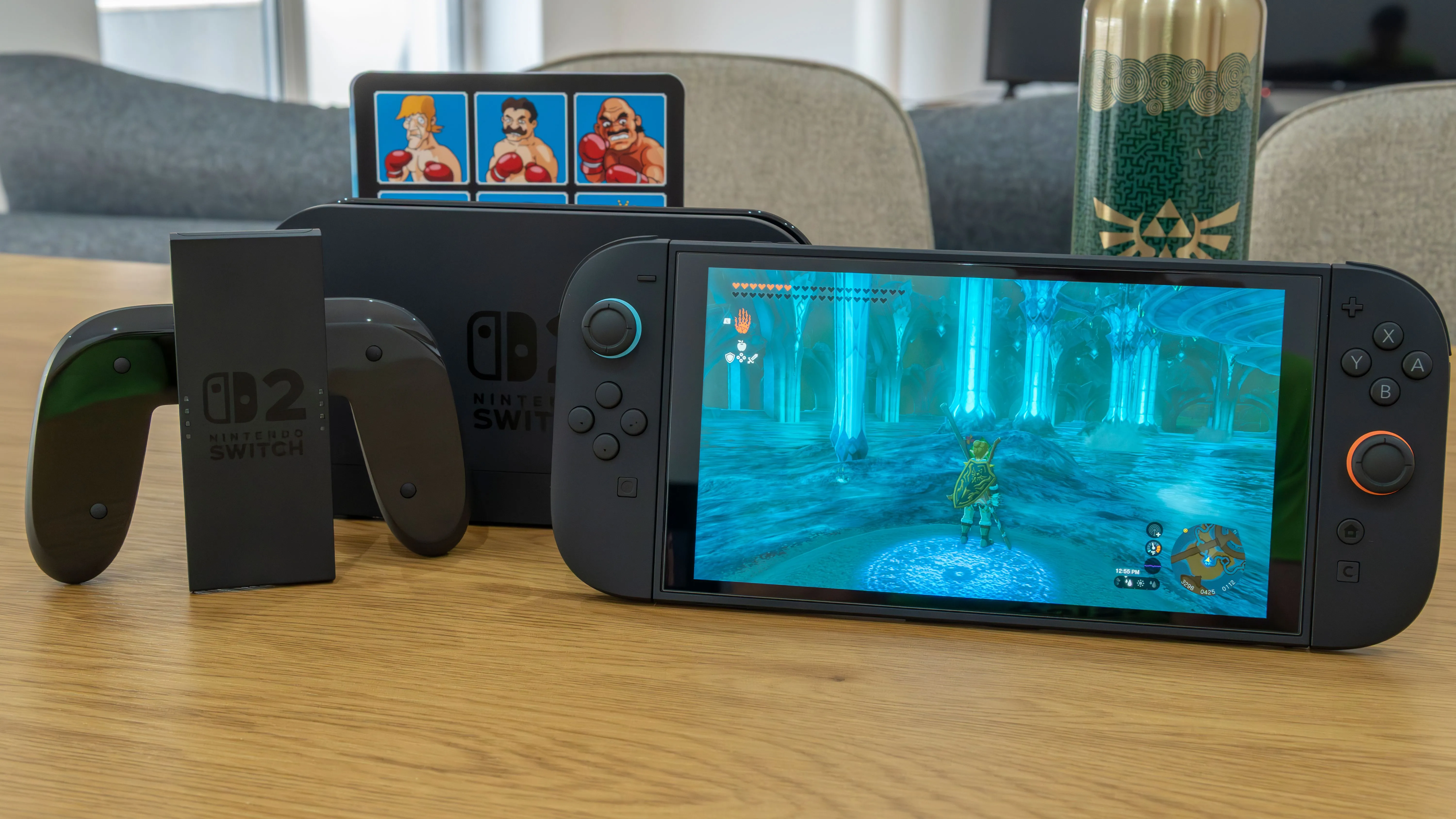 Máy chơi game Nintendo Switch 2 cùng dock và tay cầm Joy-Con trên bàn gỗ, minh họa thiết bị console thế hệ mới của Nintendo.