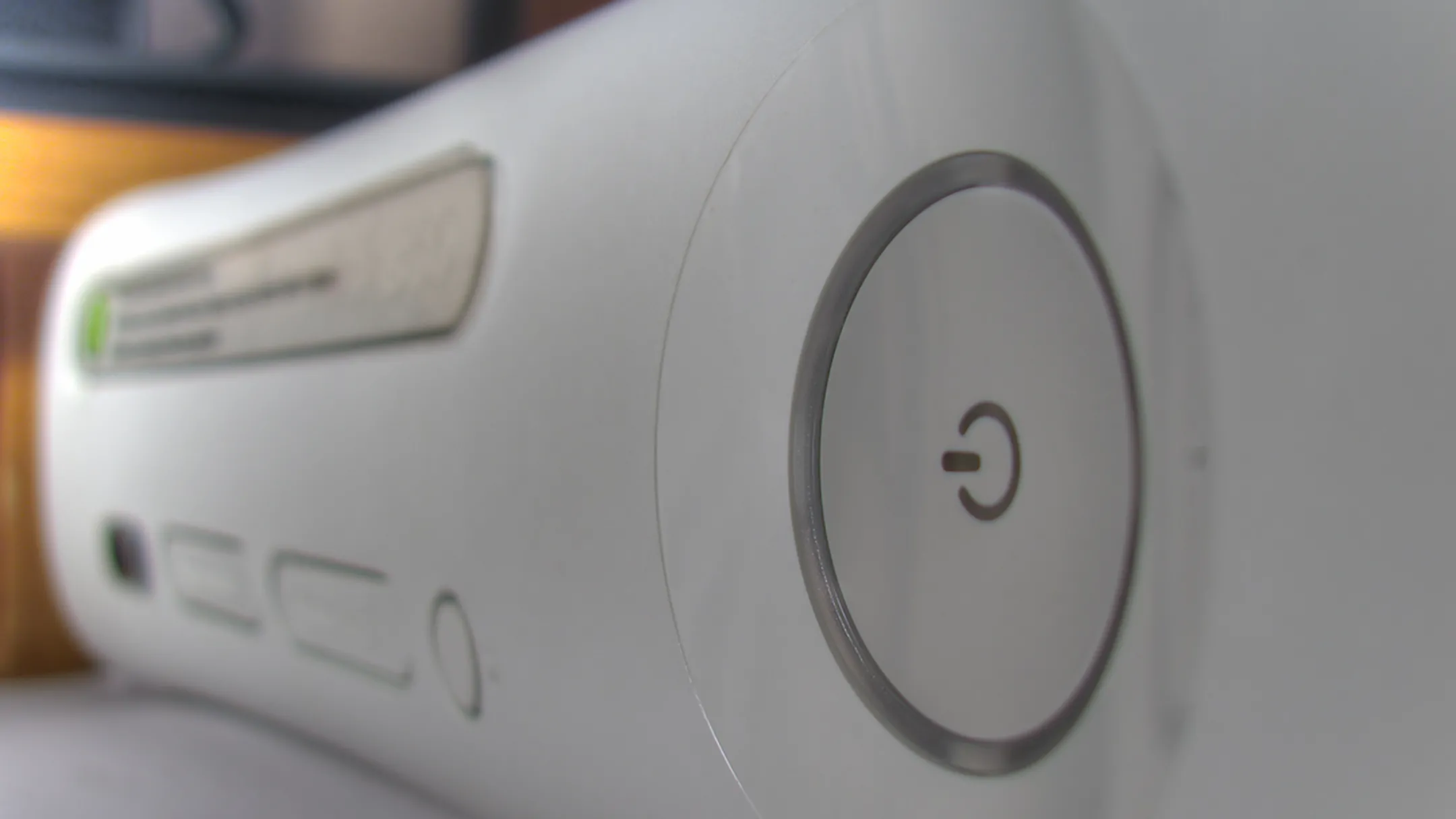 Máy chơi game Xbox 360 màu trắng với logo Xbox phát sáng, minh họa hệ thống bảo mật của Microsoft