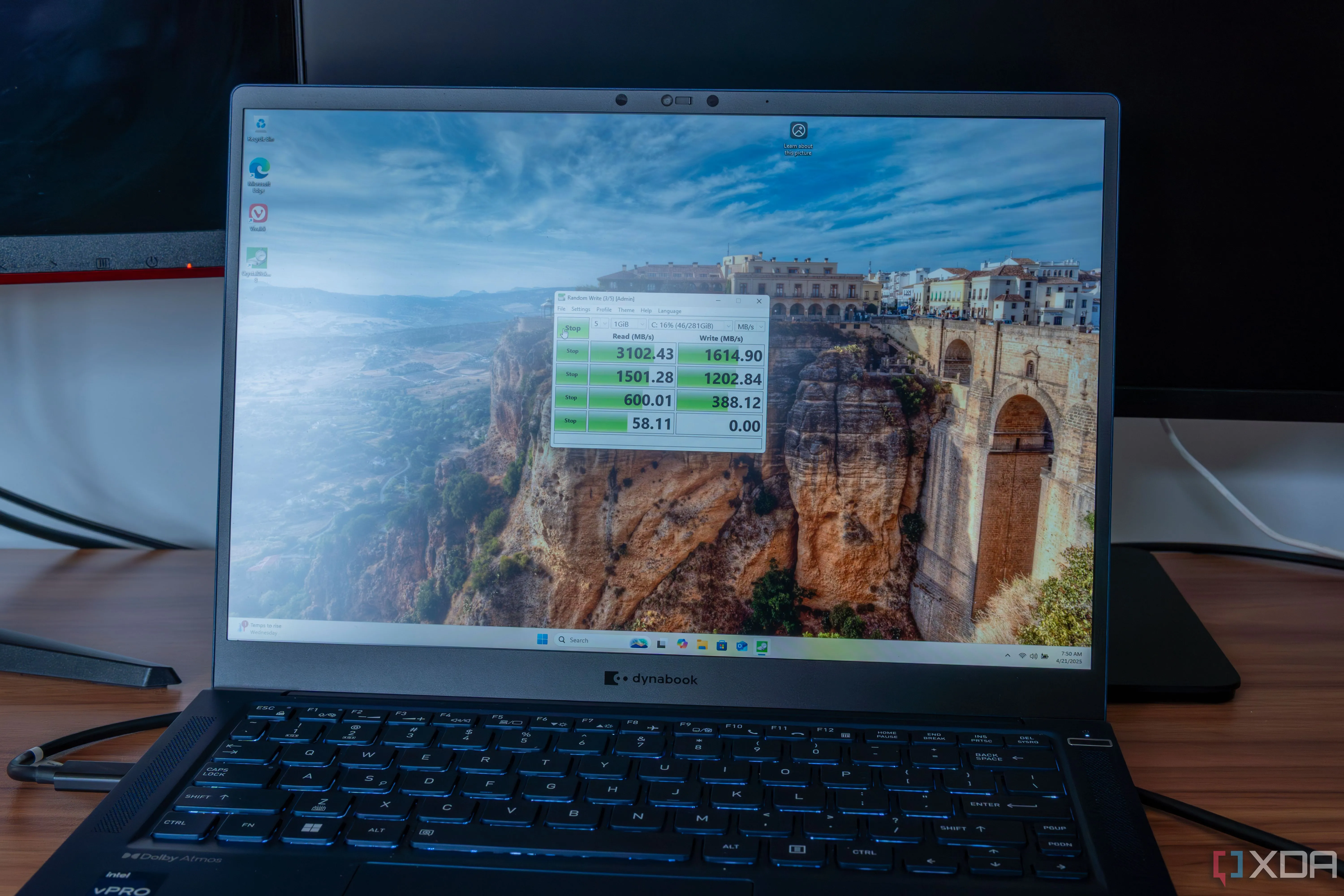 Máy tính xách tay chạy Windows 11 hiển thị kết quả kiểm tra hiệu năng ổ đĩa bằng CrystalDiskMark.
