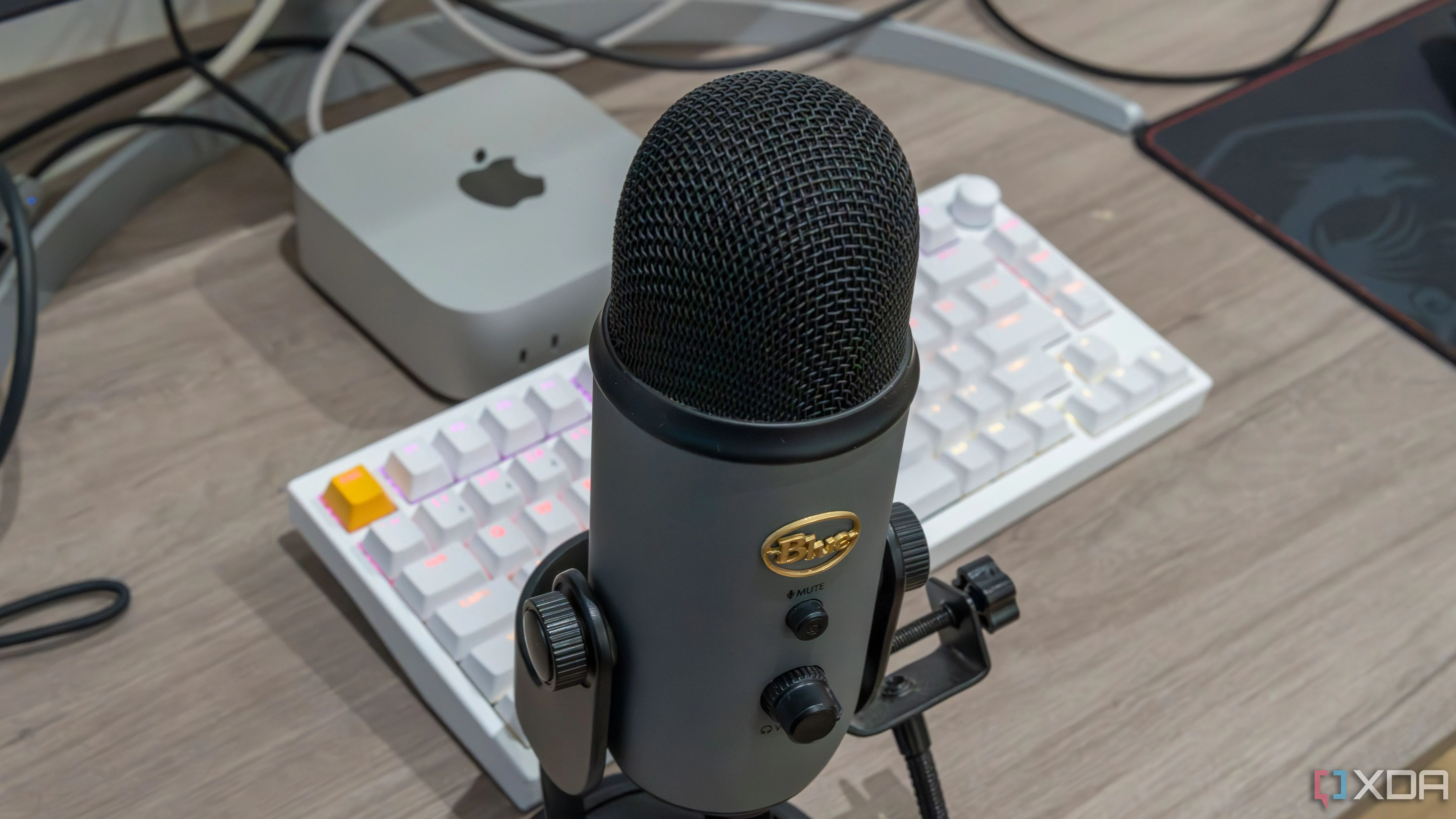Microphone USB Blue Yeti đặt trước Mac Mini và bàn phím, tượng trưng cho trải nghiệm chat thoại trong game kinh dị