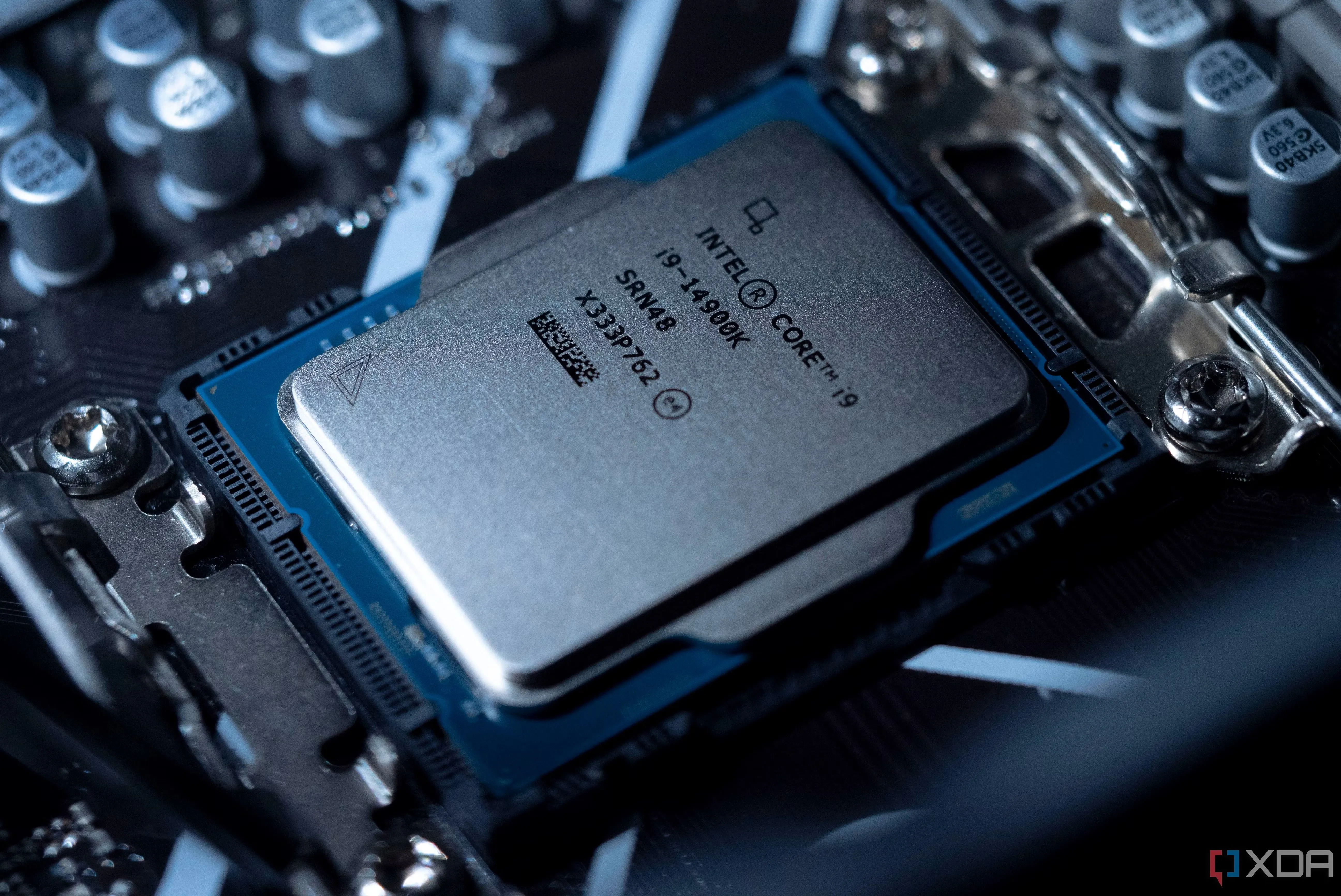 Một bộ vi xử lý Intel Core i9-14900K đang được đặt trong socket trên bo mạch chủ, chuẩn bị cho quá trình lắp đặt hoặc kiểm tra.