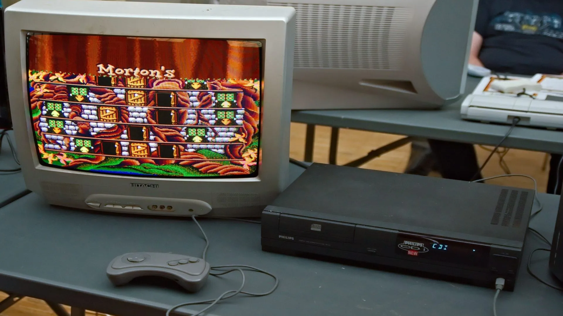 Một chiếc máy chơi game Philips CD-i đang chạy tựa game Hotel Mario tại một sự kiện, minh họa cho phần cứng CD-i và các tựa game Mario ít được biết đến trên nền tảng này, một phần của lịch sử hợp tác Nintendo-Philips.