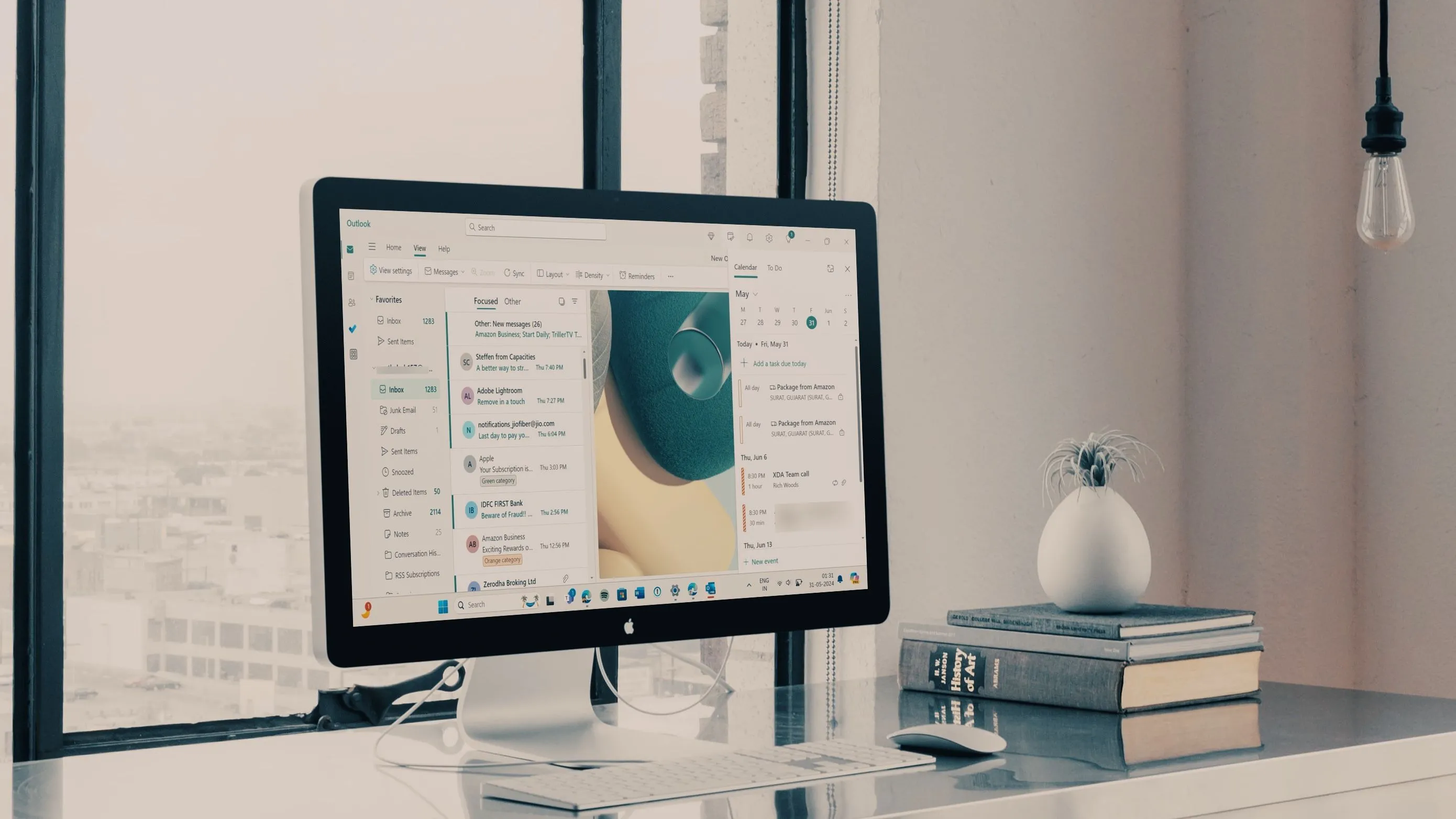 Một máy tính đang mở ứng dụng Outlook trên màn hình nền, tượng trưng cho việc quản lý email