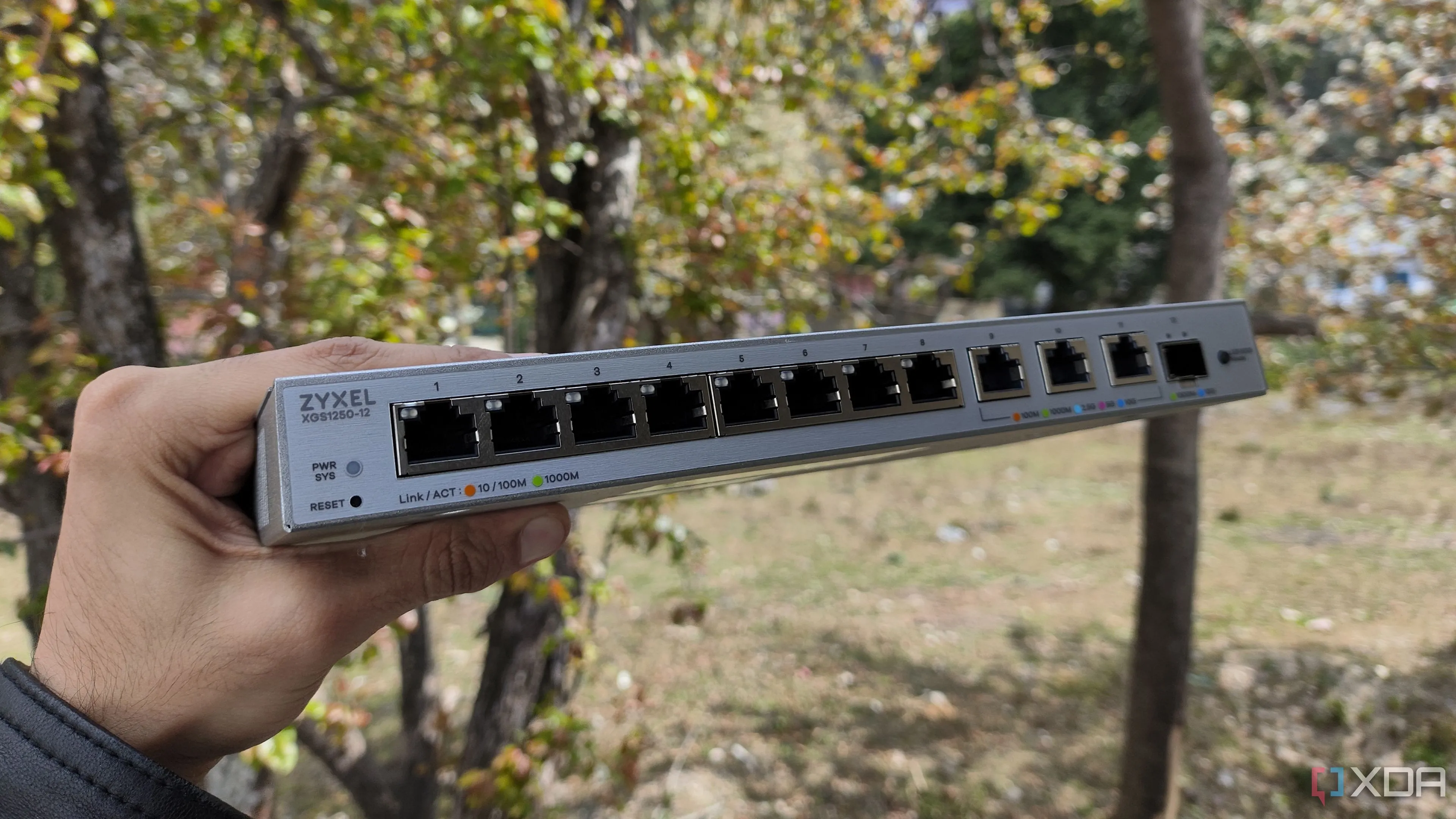 Một người đang cầm bộ chuyển mạch mạng Zyxel 2.5 GbE, minh họa cho thiết bị switch cần thiết để nâng cấp mạng gia đình