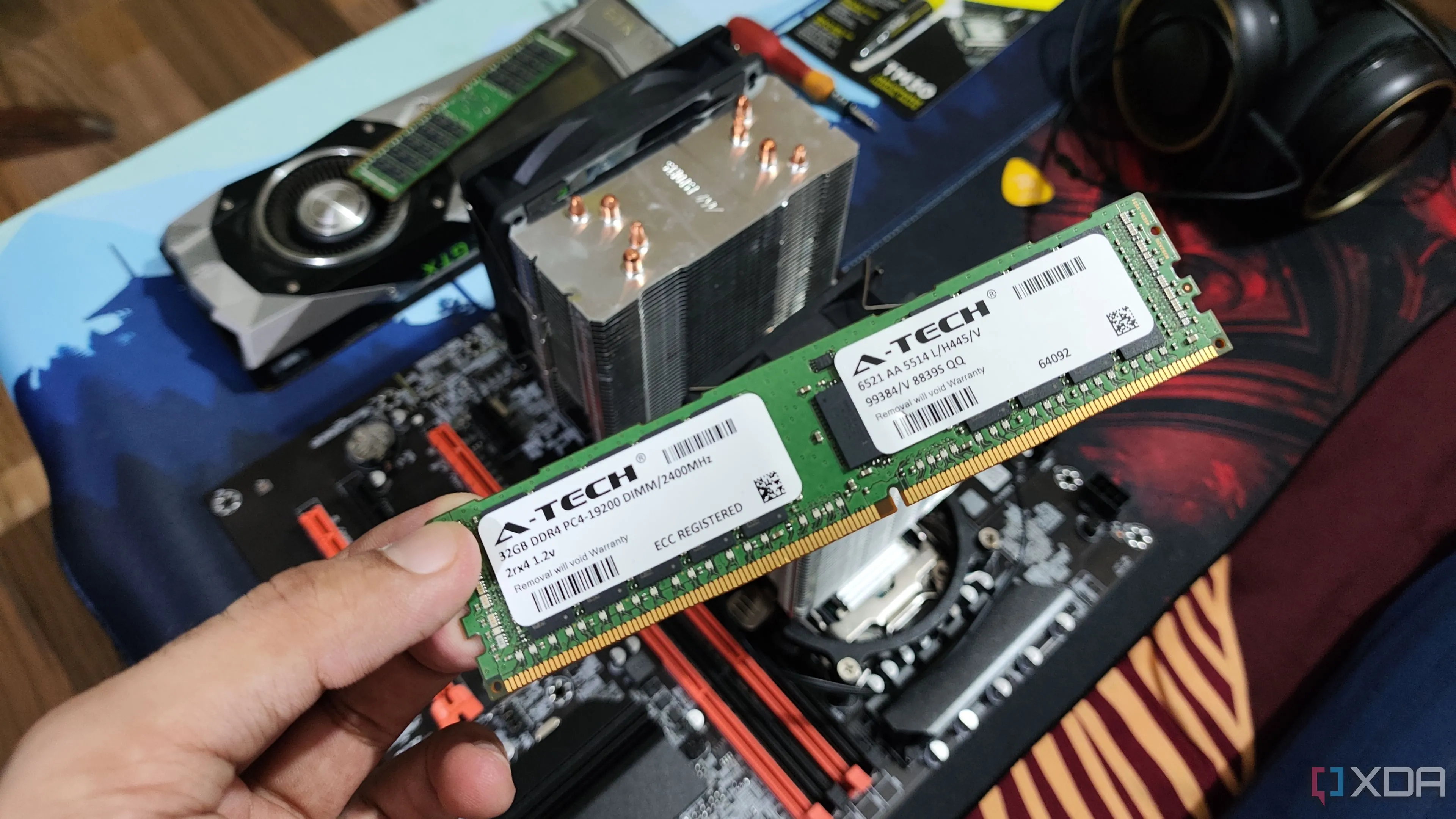 Một người đang cầm mô-đun RAM ECC, phía sau là PC server và các linh kiện khác, minh họa cho việc sử dụng bộ nhớ sửa lỗi trong môi trường Home Lab.