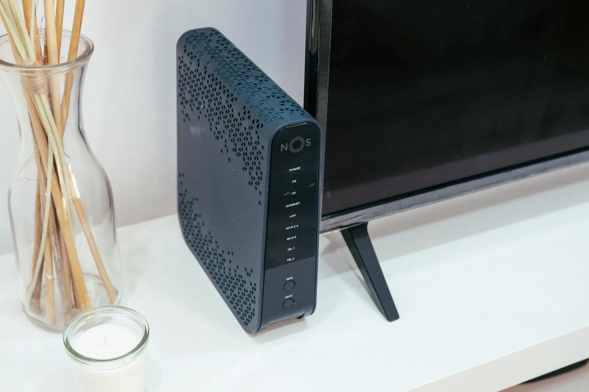 Một router hiện đại đặt cạnh tivi và lư trầm hương, tượng trưng cho việc tích hợp công nghệ vào không gian sống.