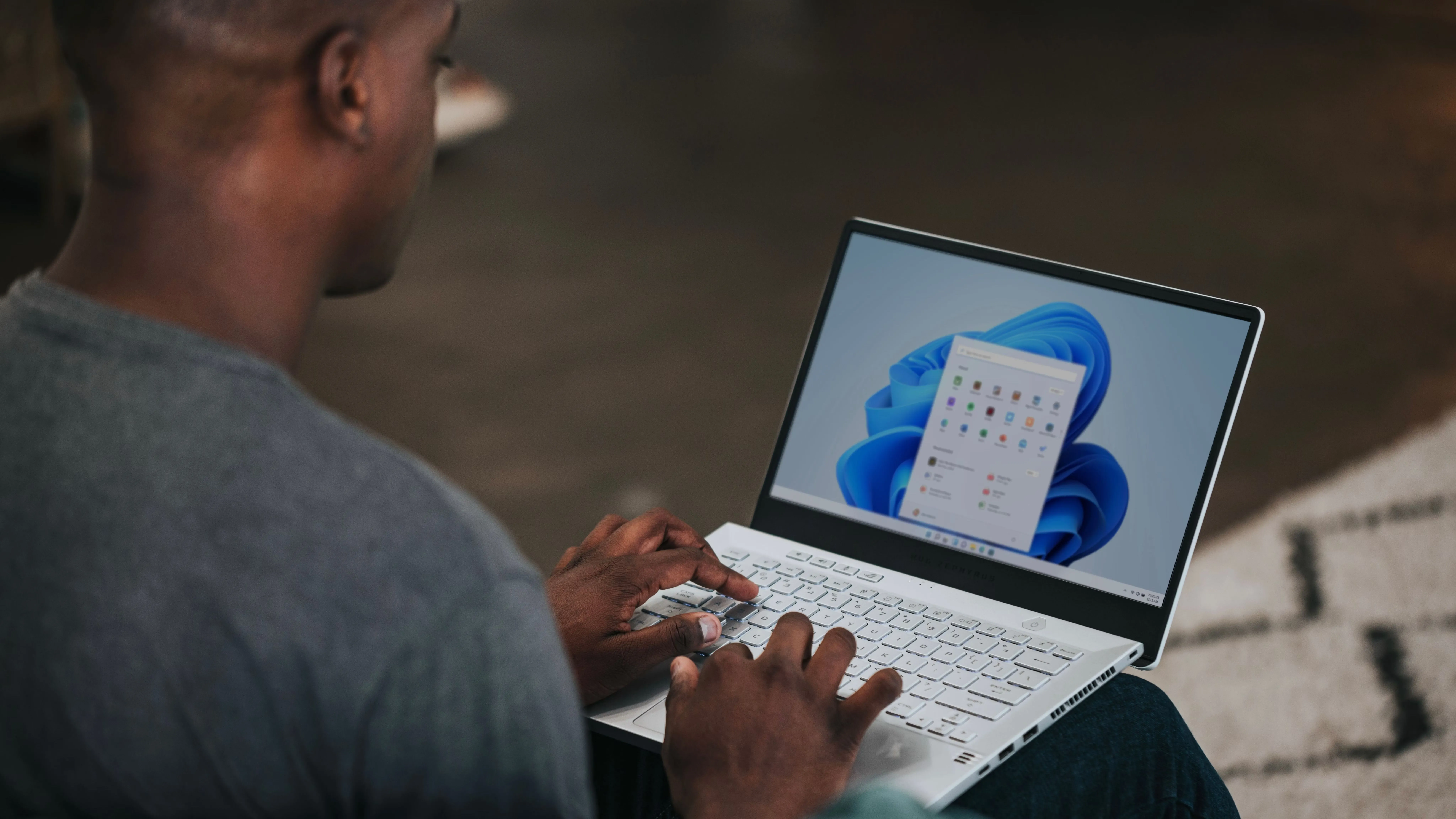 Người đàn ông sử dụng laptop chạy Windows 11 để sao lưu dữ liệu