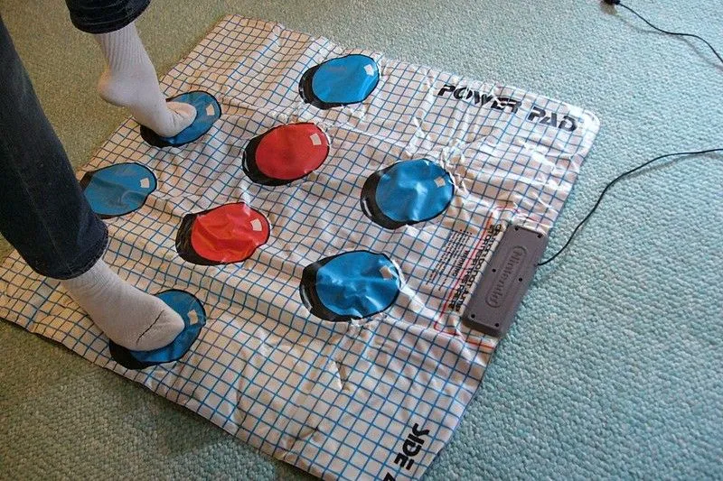 Người đang đứng trên NES Power Pad màu xám và xanh