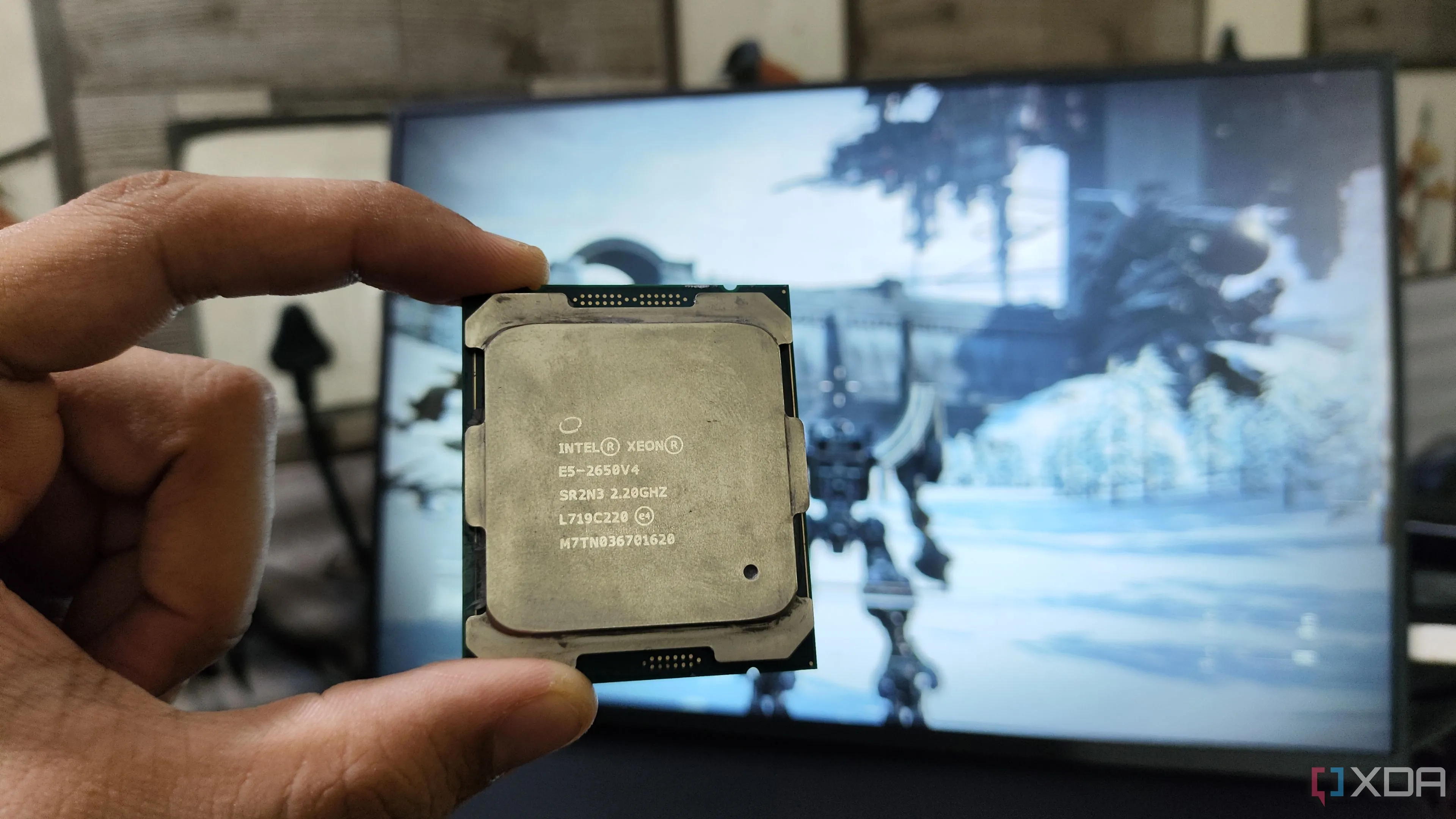 Người dùng cầm CPU Intel Xeon E5-2650 v4 chuẩn server trước màn hình máy tính