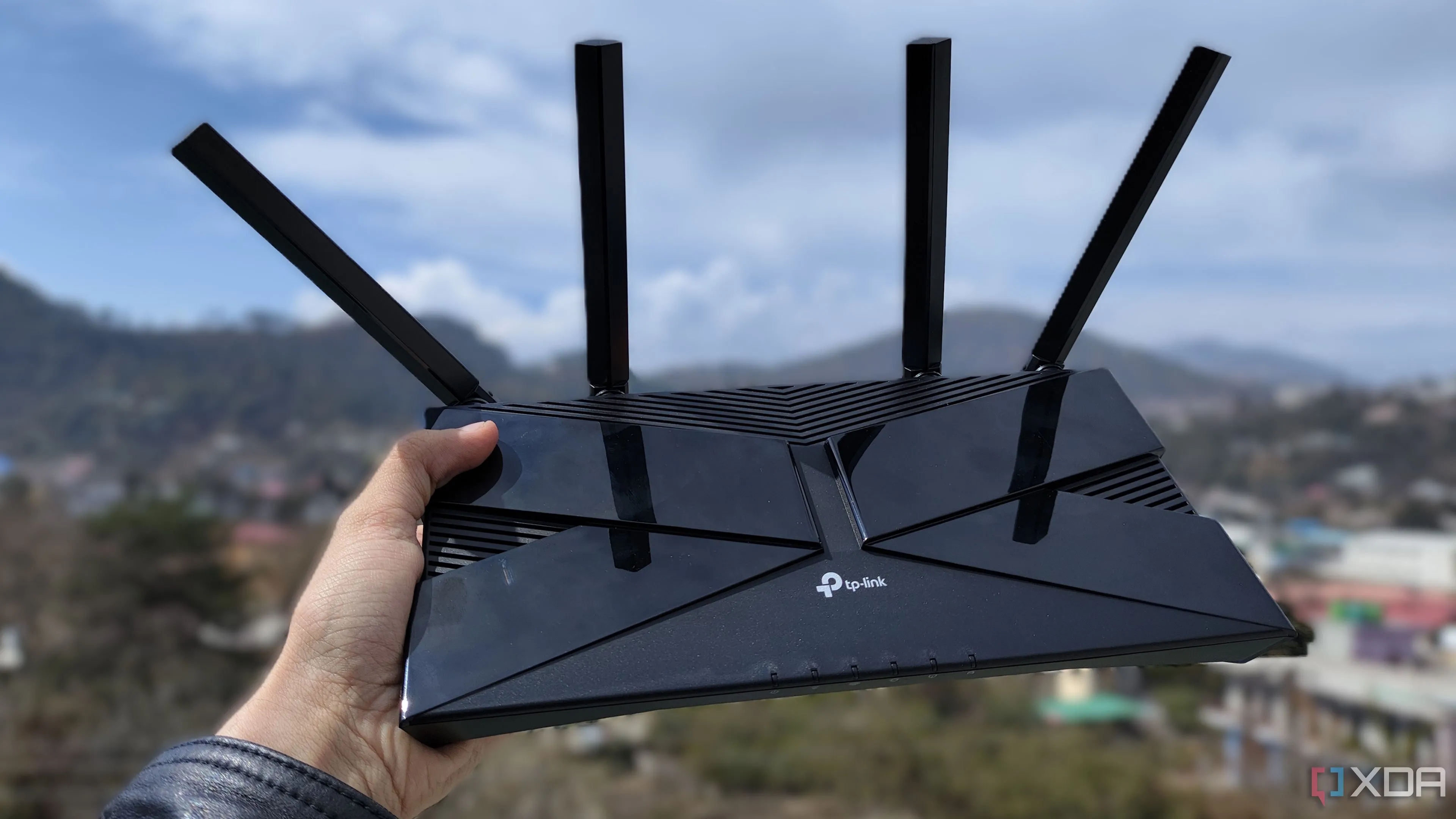Người dùng đang cầm bộ định tuyến TP-Link, biểu tượng cho thiết bị mạng gia đình cần tối ưu.
