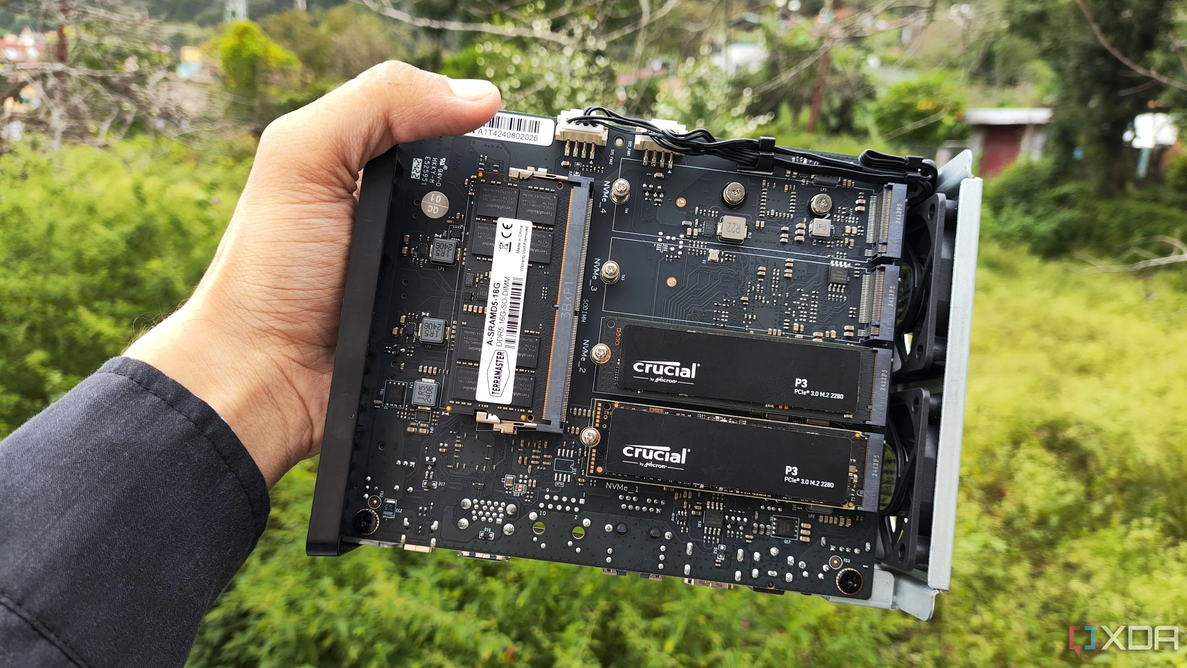 Người dùng đang cầm thiết bị NAS TerraMaster F8 SSD Plus với hai ổ SSD PCIe 3 được cắm vào, minh họa giải pháp lưu trữ mạng cho home server