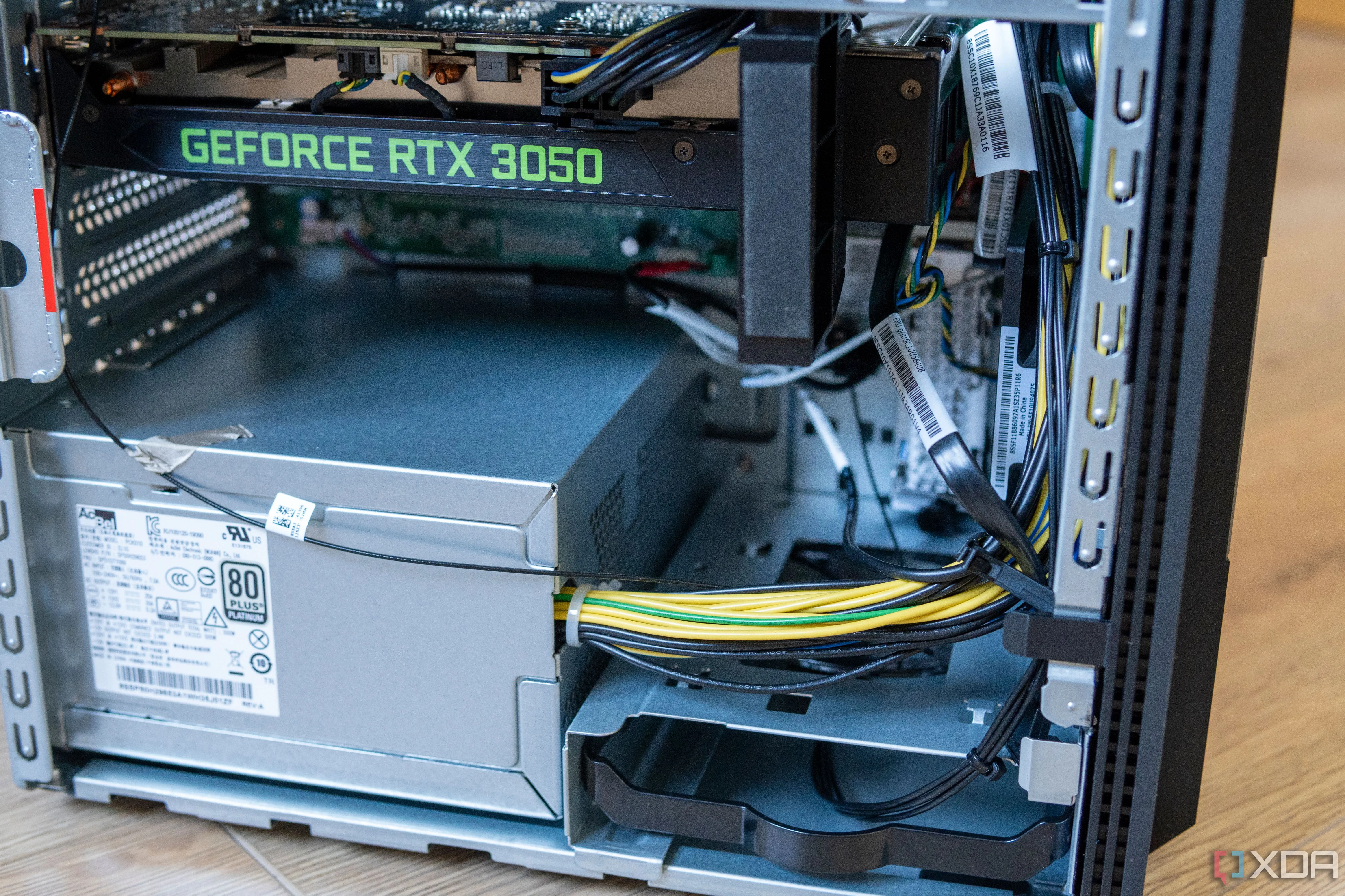 Nguồn máy tính (PSU) và các linh kiện bên trong case Lenovo LOQ Tower 17, bao gồm GPU và khay ổ cứng.