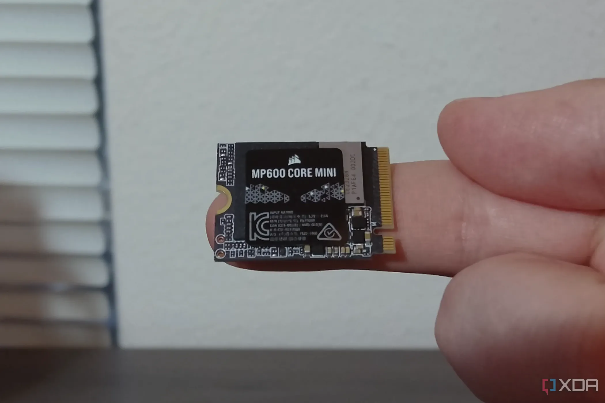 Ổ SSD Corsair MP600 Core Mini M.2 NVMe nhỏ gọn được giữ trên ngón tay, minh họa keying loại M