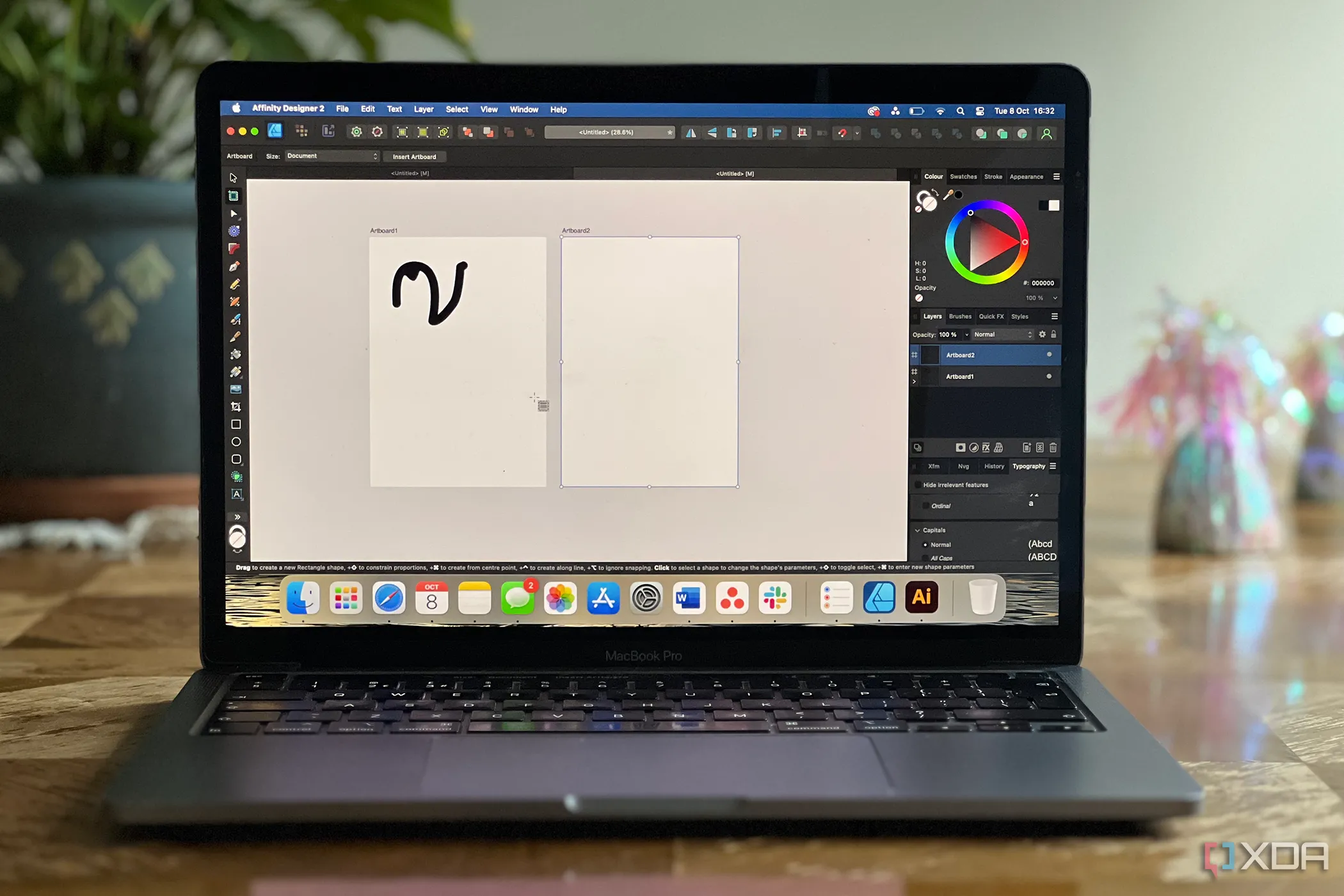 Phần mềm Affinity Designer đang hoạt động trên màn hình MacBook Pro, đặt trên mặt bàn màu nâu.