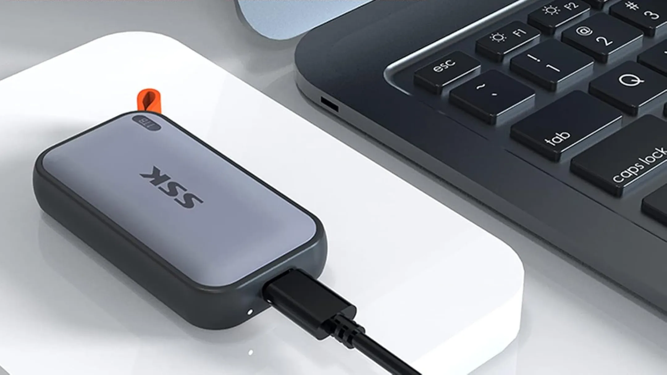SSD di động SSK bên cạnh máy tính, minh họa tính tiện dụng