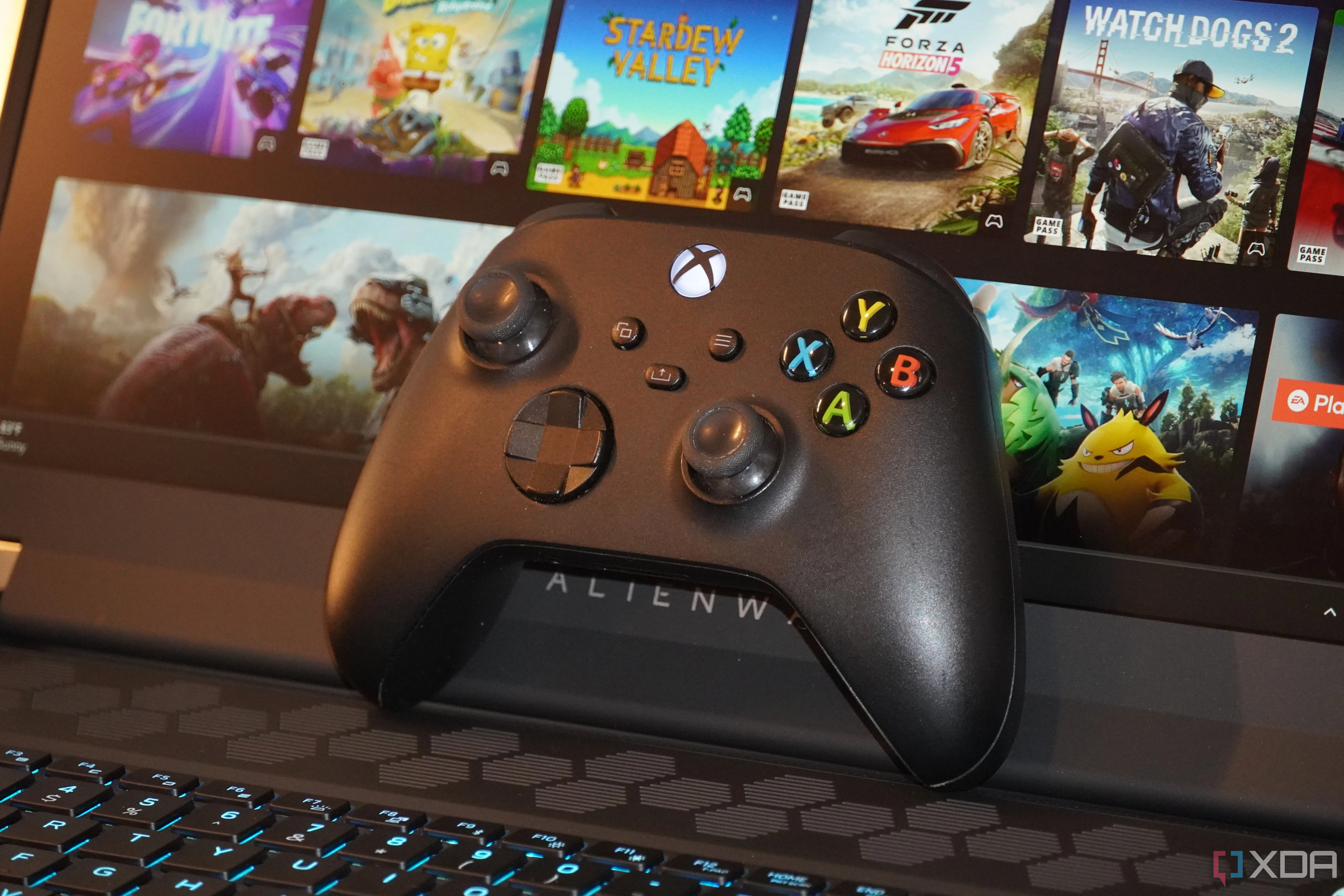 Tay cầm Xbox kết nối với laptop chơi game Alienware, tượng trưng cho mong muốn chơi game console trên PC.