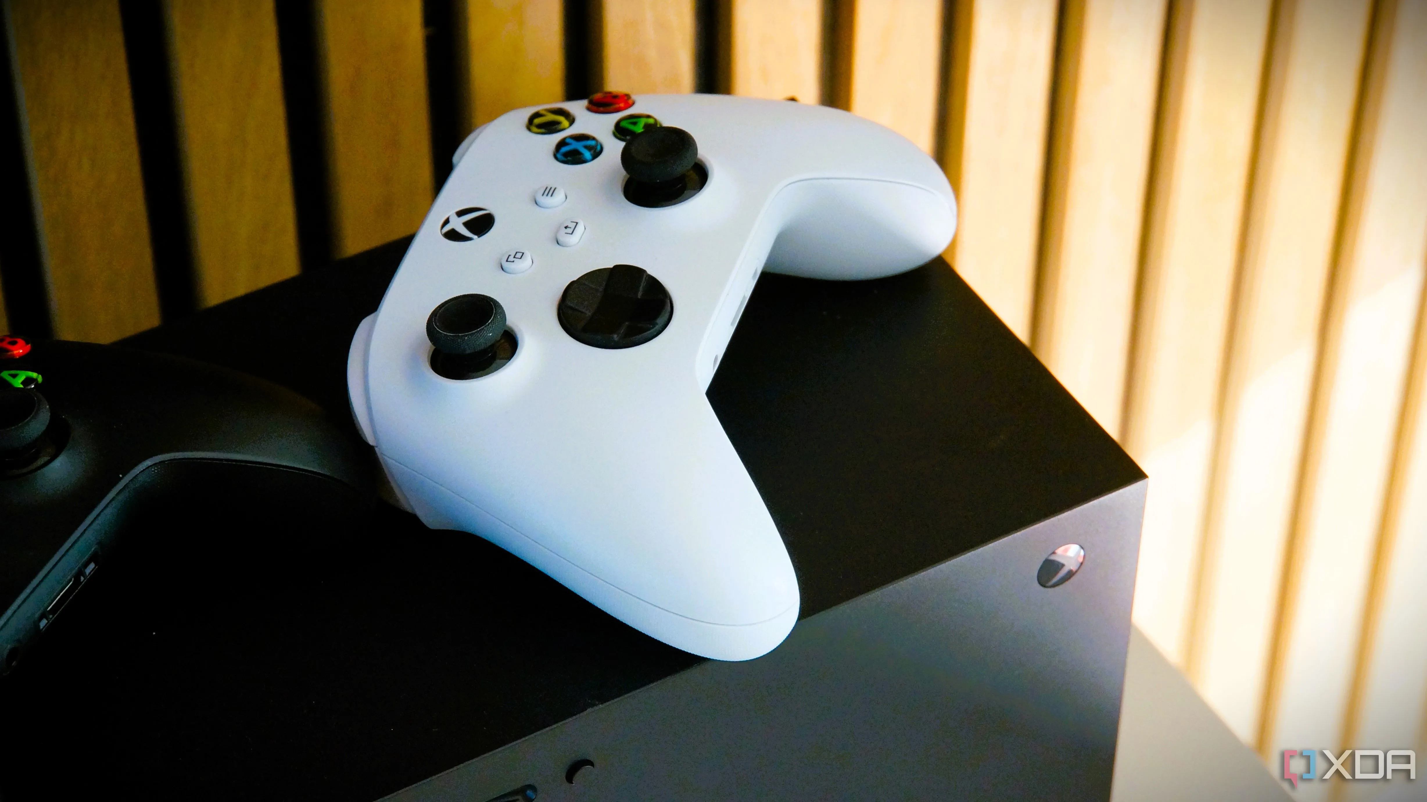 Tay cầm Xbox màu trắng đặt trên đỉnh của máy chơi game Xbox Series X