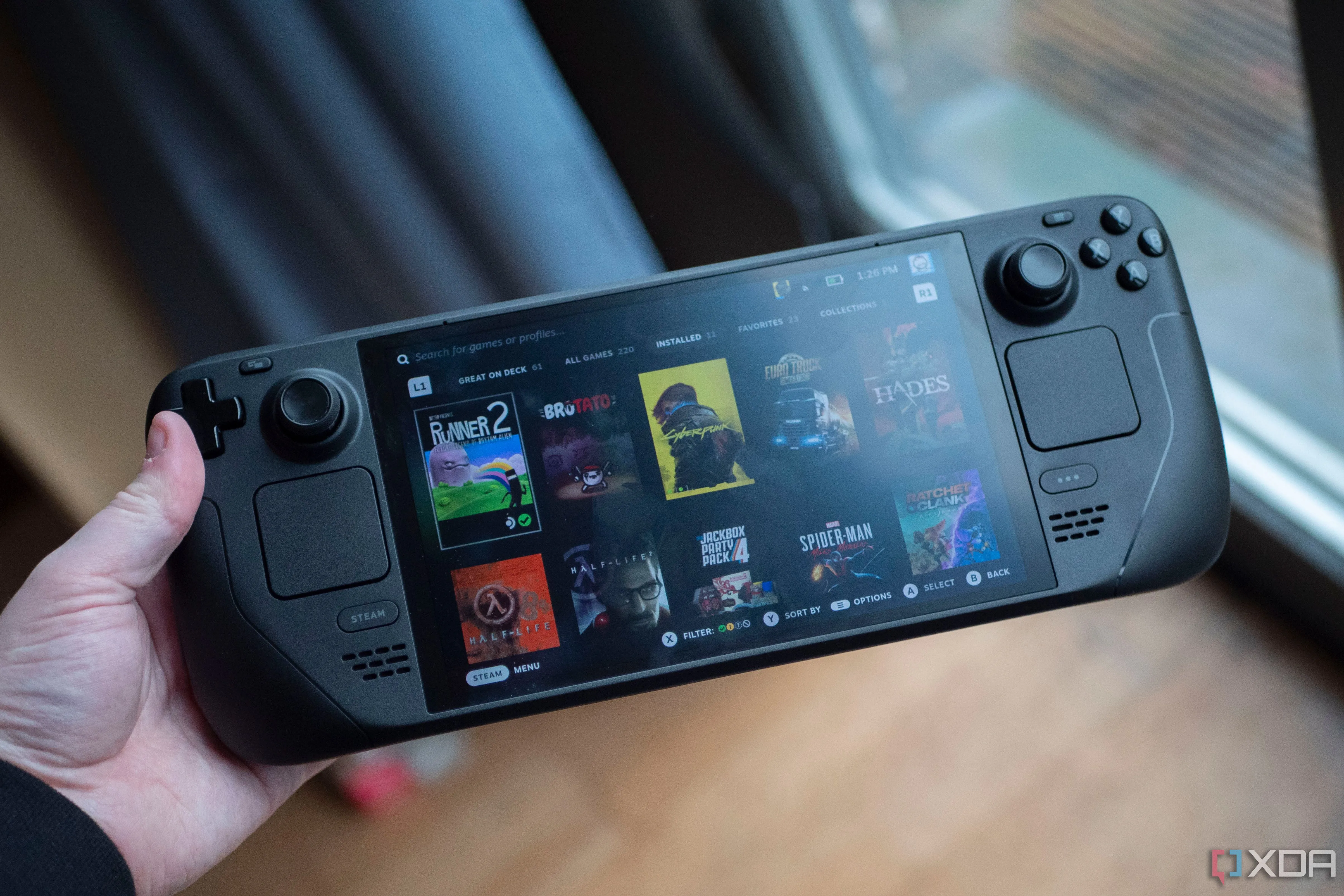 Thiết bị chơi game cầm tay Steam Deck OLED với màn hình sáng và hai tay cầm, minh họa tính di động của PC gaming